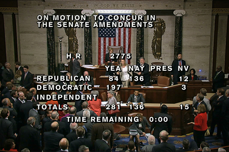 Diane Reidy, seen between the "yea" and "nay" wording, is removed from the House chamber after she began shouting during the vote to end the government shutdown. (AP/House TV)