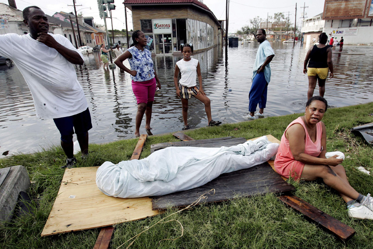 Evelyn Turner, right, with friends and family, waiting with the body of her common-law husband, Xavier Bowie, after he died in New Orleans, Aug. 30, 2005. (AP/Eric Gay)