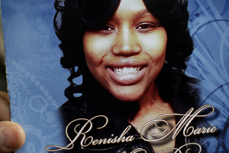 A mourner holds an obituary showing a picture of 19-year-old shooting victim Renisha McBride during her funeral service in Detroit, Michigan November 8, 2013. (Reuters/Joshua Lott)