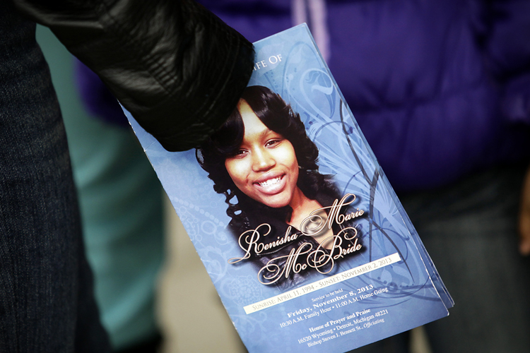 A mourner holds an obituary displaying a picture of shooting victim Renisha McBride during her funeral service in Detroit, November 8, 2013. (Reuters/Joshua Lott)