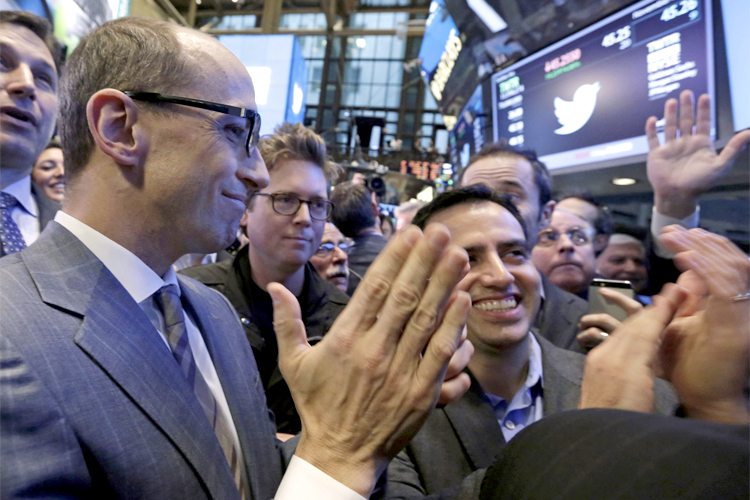Twitter CEO Dick Costolo, left, co-founder Biz Stone, center, and Amir Movafaghi, right, Twitter's Director of Treasury and Strategic Finance, applaud as shares begin trading in their IPO, on the floor of the New York Stock Exchange, Nov. 7, 2013. (AP/Richard Drew)