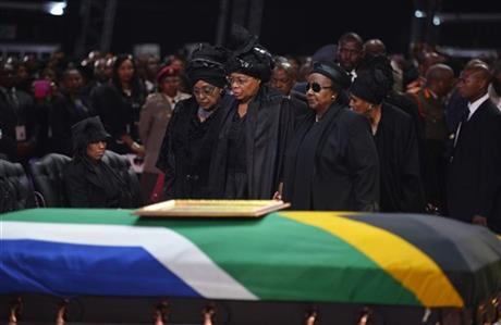 Winnie Madikizela-Mandela, left, Nelson Mandela's former wife, left and Nelson Mandela’s widow Graca Machel stand over the former South African president's casket during his funeral service in Qunu, South Africa, Sunday. (AP)