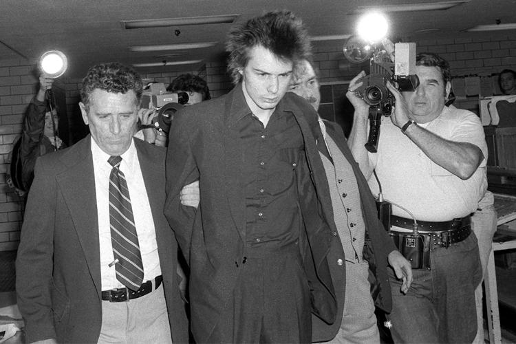 New York police escort Sid Vicious, shortly before he was charged with murder in the stabbing death of Nancy Spungen, at New York's Chelsea Hotel, Oct. 13, 1978. (AP)