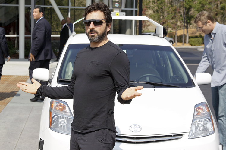 Sergey Brin gestures after riding in a driverless car with California Gov. Jerry Brown. (AP/Eric Risberg)