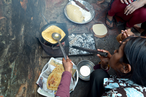 A woman cooking chapatis in oil to make pancakes, on February 4, 2013 in Delhi, India. (africa924/Shutterstock)