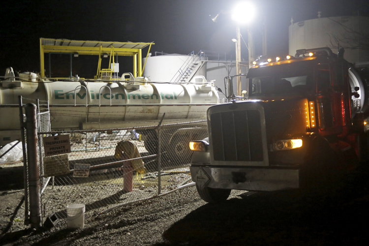 Workers at Freedom Industries work to empty storage tanks of chemicals into tanker trucks, Charleston, Va., Jan. 12, 2014. (AP/Steve Helber)