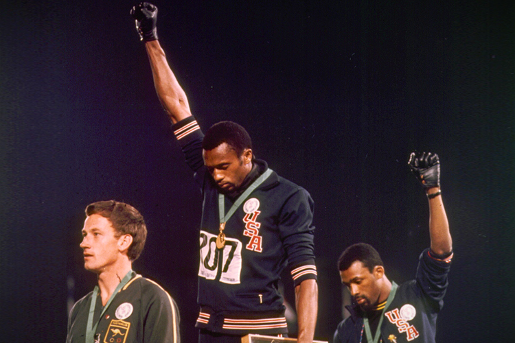 Tommy Smith, center, and John Carlos wear black gloves on upraised right hands during playing of U.S. National Anthem in Mexico City on Oct.16, 1968. (AP)
