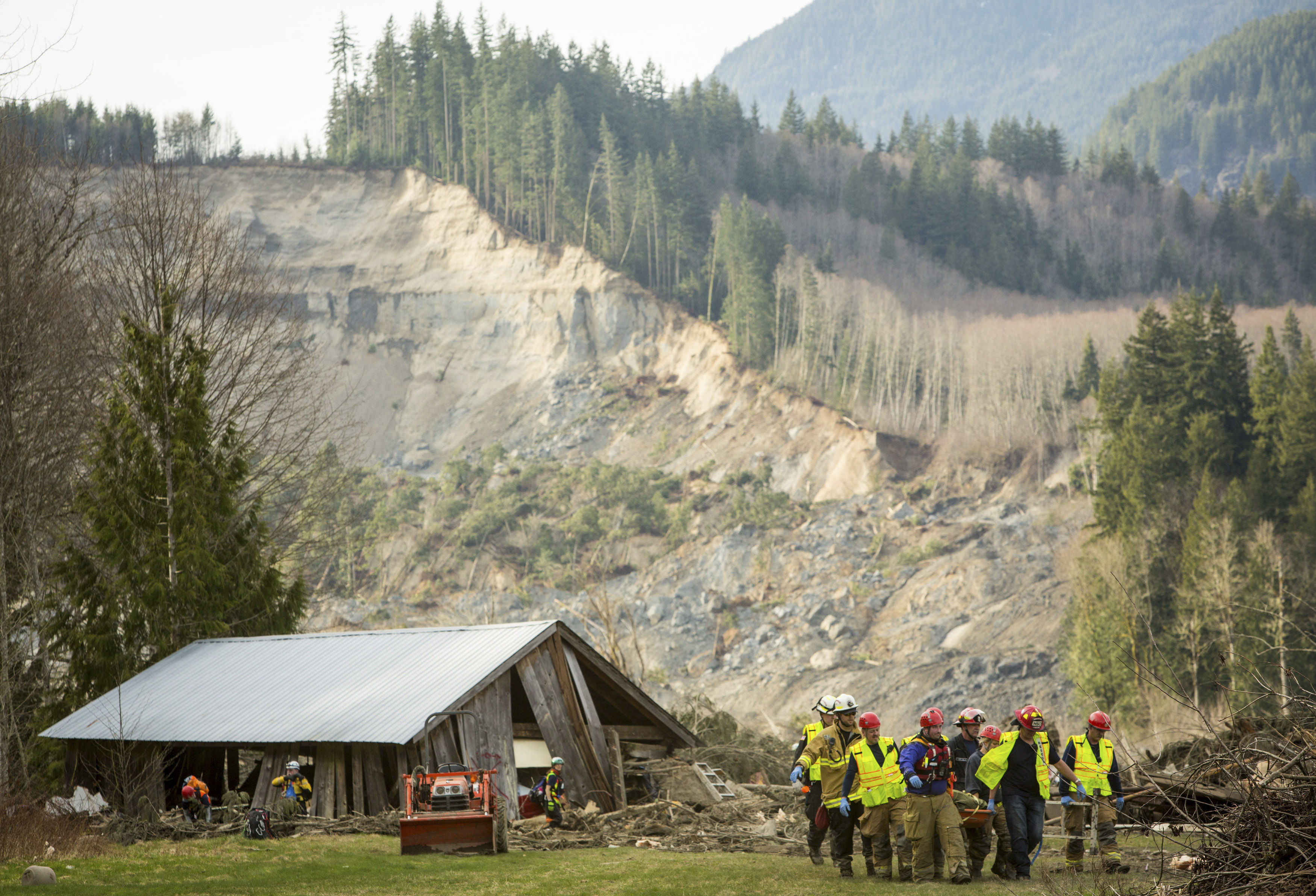 Rescue workers remove one of a number of bodies from the wreckage of homes destroyed by a mudslide near Oso, Wash., Monday, March 24, 2014. (AP Photo/seattlepi.com, Joshua Trujillo)