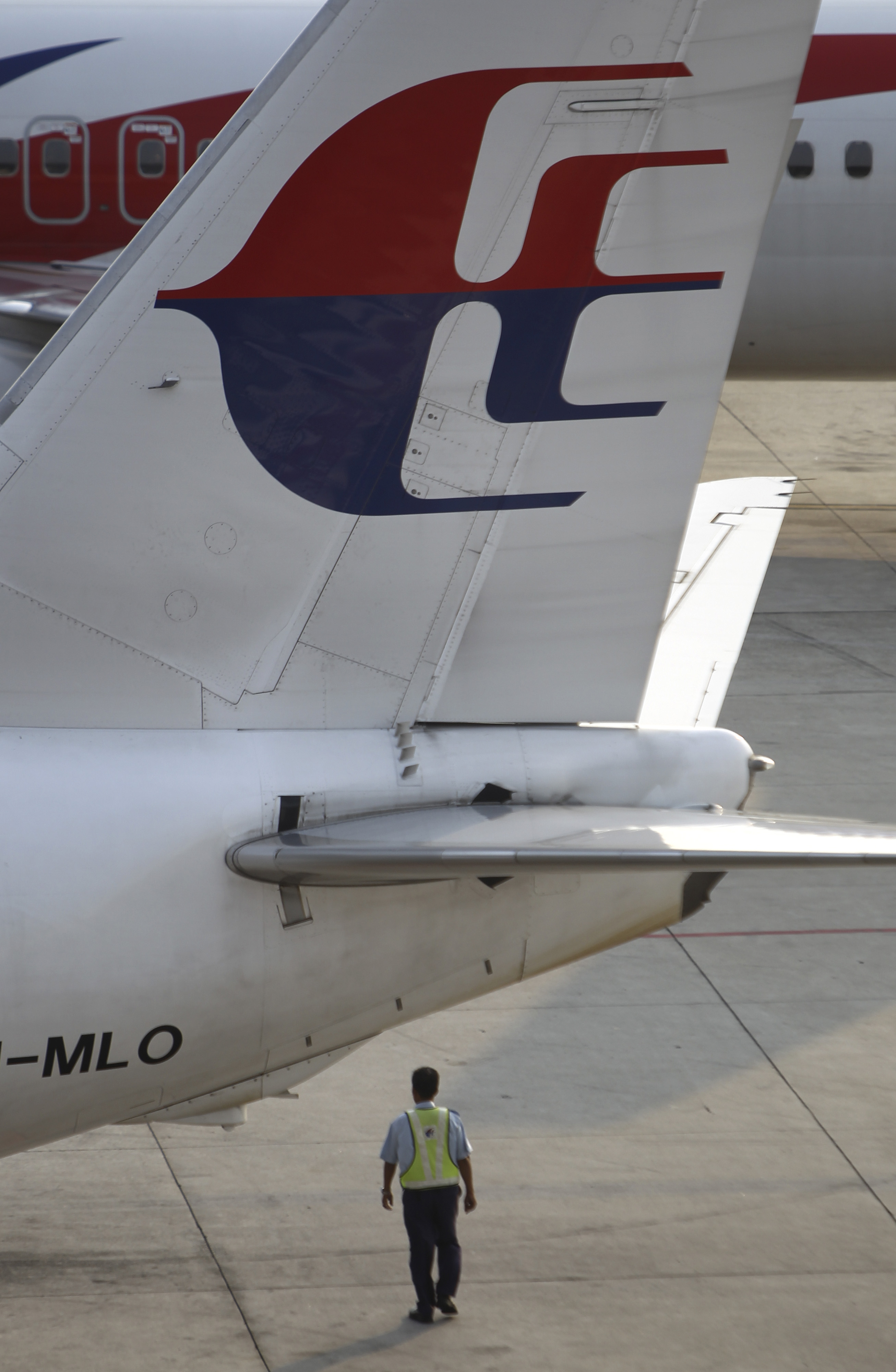 A ground staff member walks under a Malaysia Airlines plane at Kuala Lumpur International Airport in Sepang, Malaysia, Wednesday, March 12, 2014. The missing Malaysian jetliner may have attempted to turn back before it vanished from radar, but there is no evidence it reached the Strait of Malacca, Malaysia's air force chief said Wednesday, denying reported remarks he said otherwise. The statement suggested continued confusion over where the Boeing 777 might have ended up, more than four days after it disappeared en route to Beijing from Kuala Lumpur with 239 people on board. (AP Photo/Lai Seng Sin) (AP)