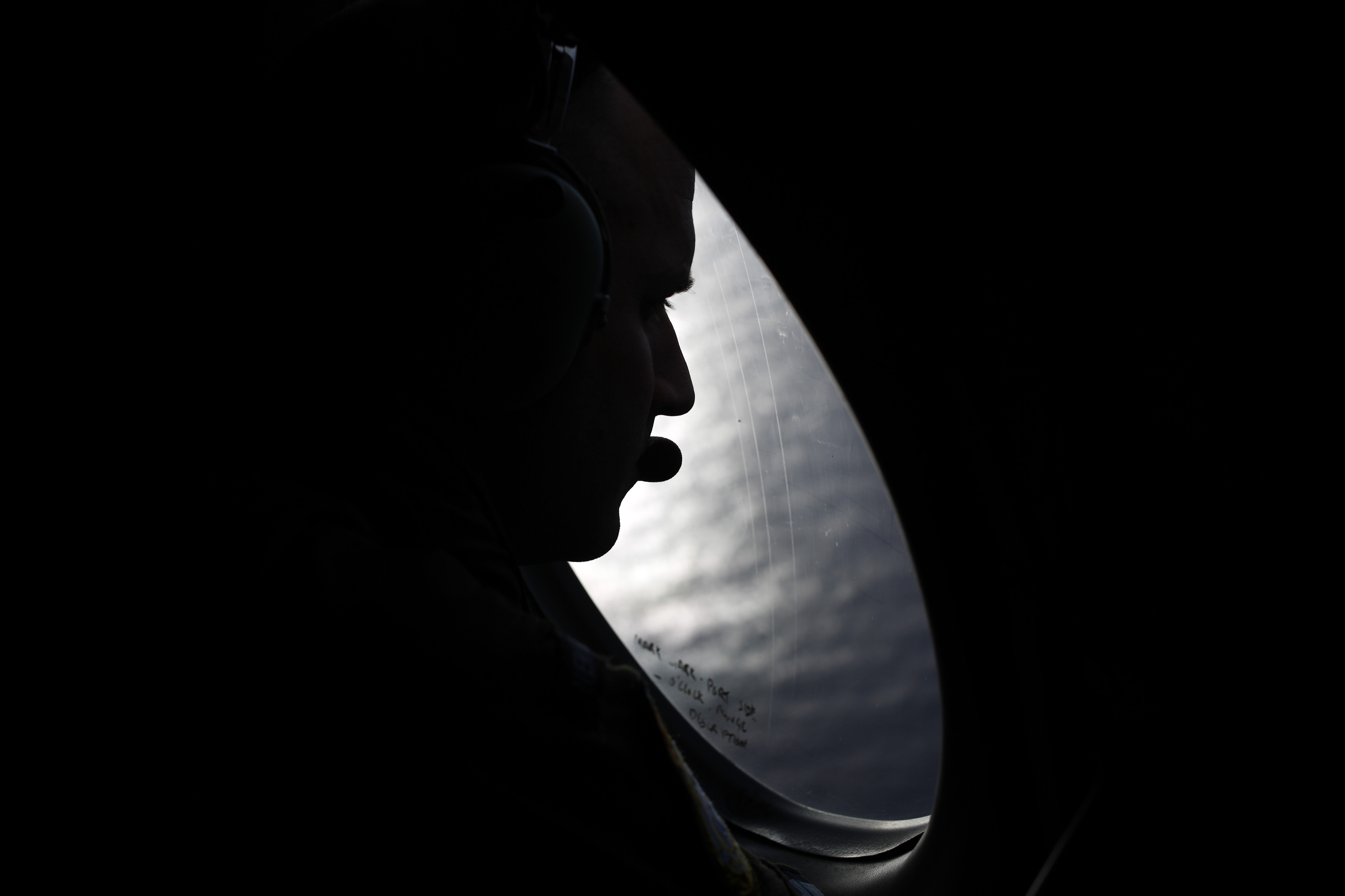 A Royal New Zealand Air Force crew member looks into the southern Indian Ocean from a P-3K2 Orion aircraft searches for missing Malaysian Airlines flight 370, Saturday, March 29, 2014. A day after the search for the Malaysian jetliner shifted to a new area of the Indian Ocean, ships on Saturday plucked objects from the sea to determine whether they were related to the missing jet. None were confirmed to be from the plane, leaving searchers with no sign of the jet three weeks after it disappeared. (AP Photo/Jason Reed, Pool) (AP)