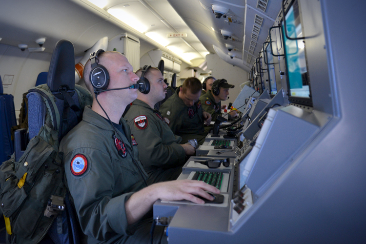 Crew members on board aircraft P-8A Poseidon assist in search and rescue operations for Malaysia Airlines flight MH370 in the Indian Ocean, March 16, 2014. (AP/Eric A. Pastor)