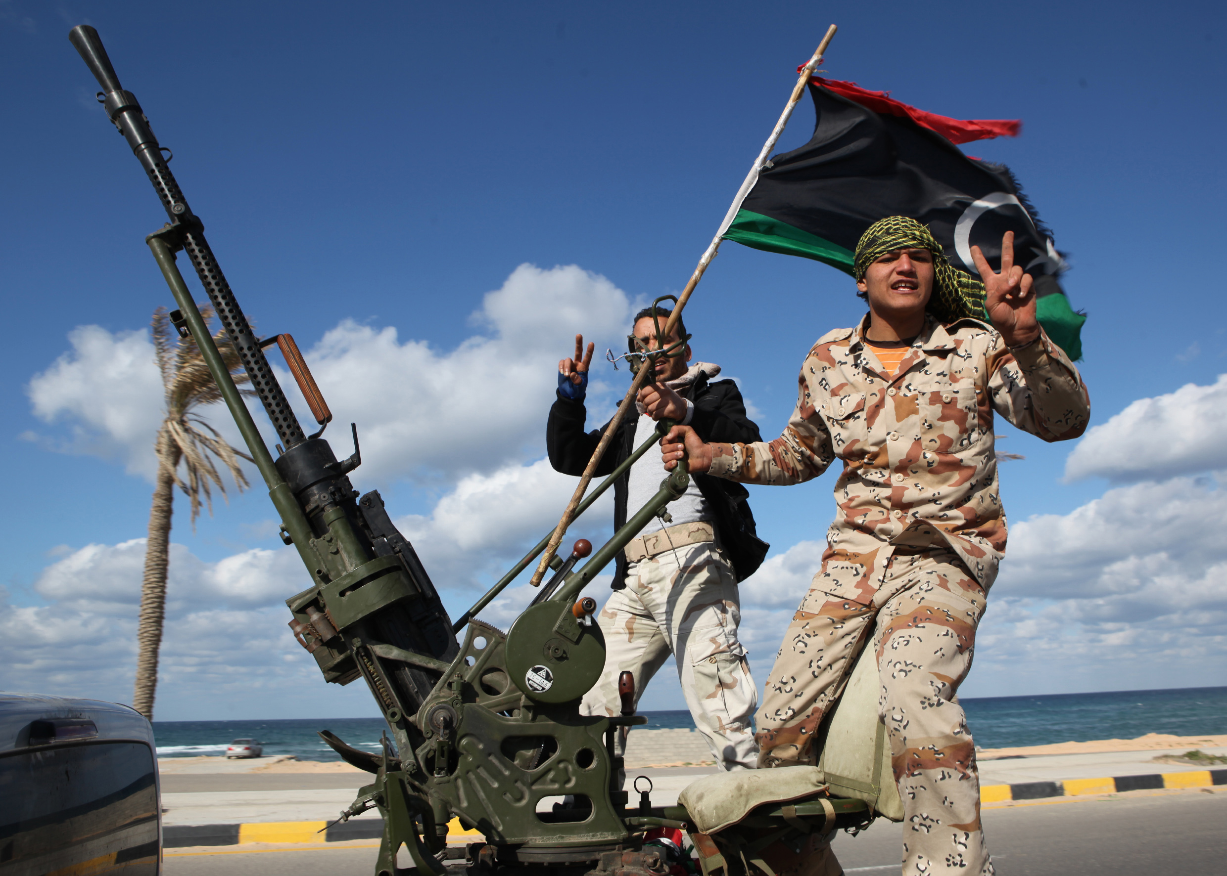 FILE - In this Tuesday Feb. 14, 2012 file photo, Libyan militias from towns throughout the country's west parade through Tripoli, Libya. At the heart of the Libyan capital, the open-air Fish Market was once where residents went to buy everything from meat and seafood to clothes and pets. Now its Tripolis biggest arms market, with tables displaying pistols and assault rifles. Ask a vendor, and he can pull out bigger machine guns to sell for thousands of dollars. (AP Photo/Abdel Magid Al Fergany, File) (AP)