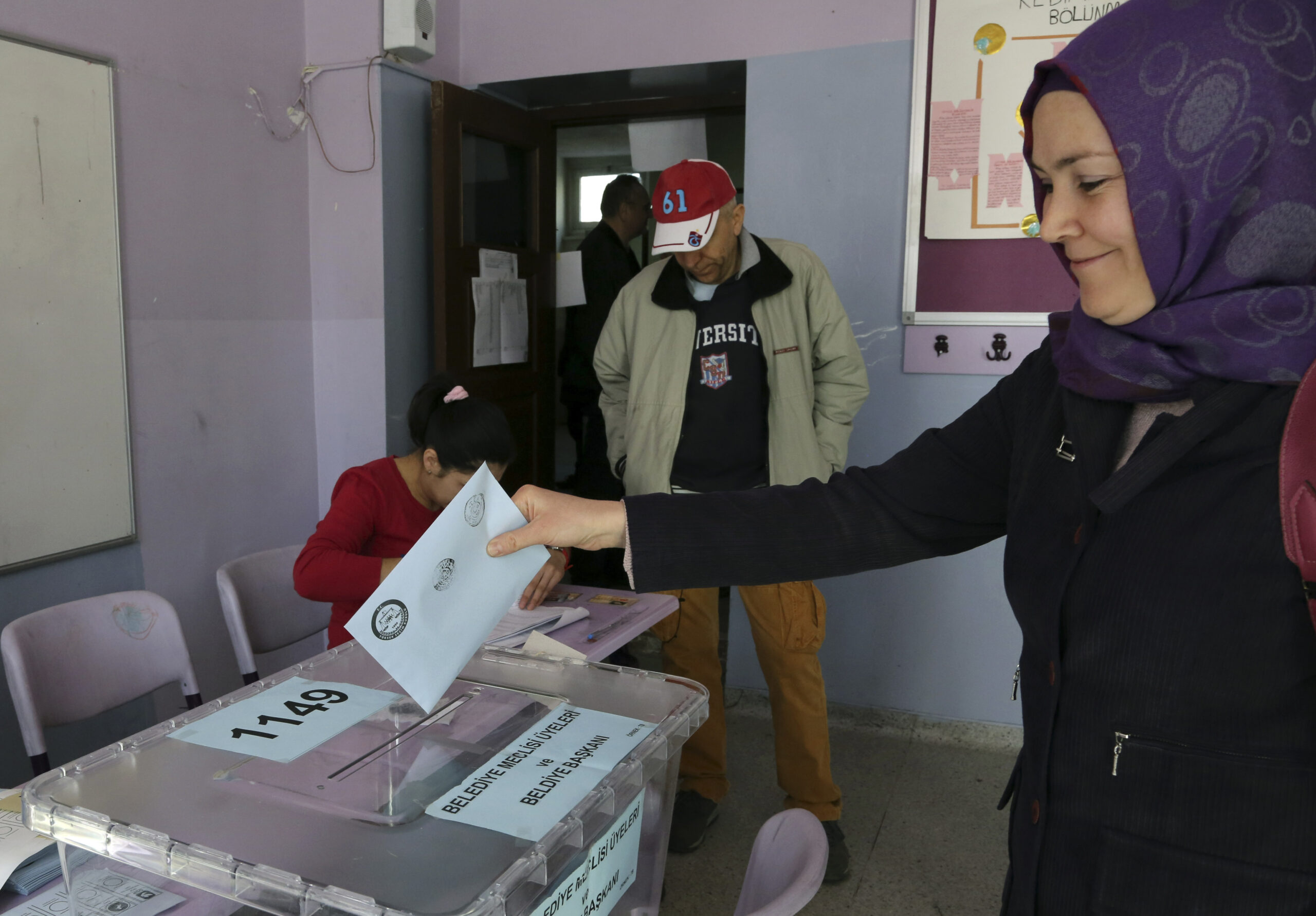 A Turkish woman casts her ballot at a polling station in Ankara Turkey, Sunday, (Burhan Ozbilici)