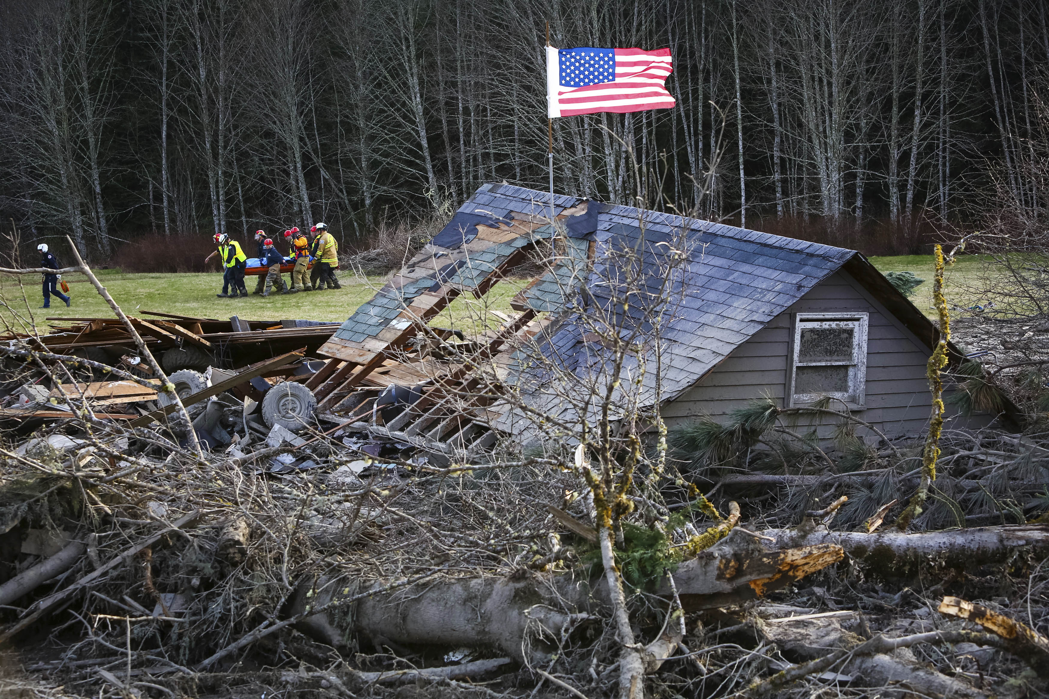 Rescue workers remove a body from the wreckage of homes destroyed by a mudslide near Oso, Wash, Monday, March 24, 2014. (AP Photo/seattlepi.com, Joshua Trujillo)