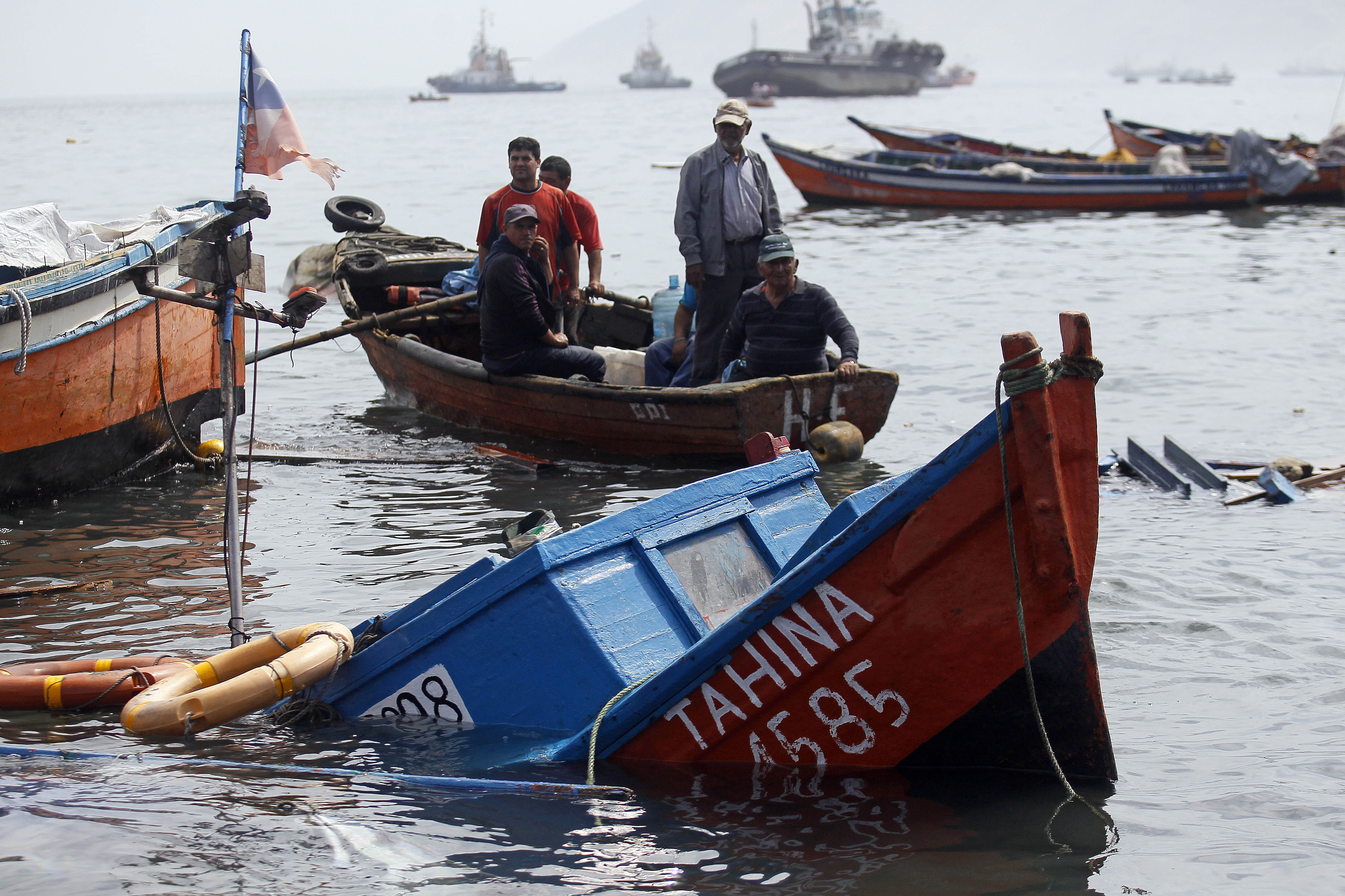 Fishermen look for boats to salvage damaged overnight in the port of Iquique, Chile, Wednesday, April 2, 2014. ( AP Photo/ Luis Hidalgo, Pool)