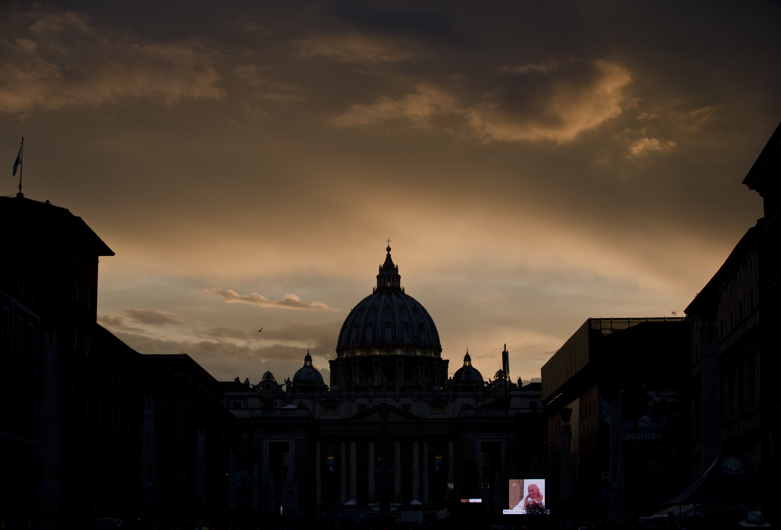 A large screen for public display shows Pope John Paul II after sunset outside St. Peter's Square at the Vatican, Saturday, April 26, 2014. (AP Photo/Vadim Ghirda)