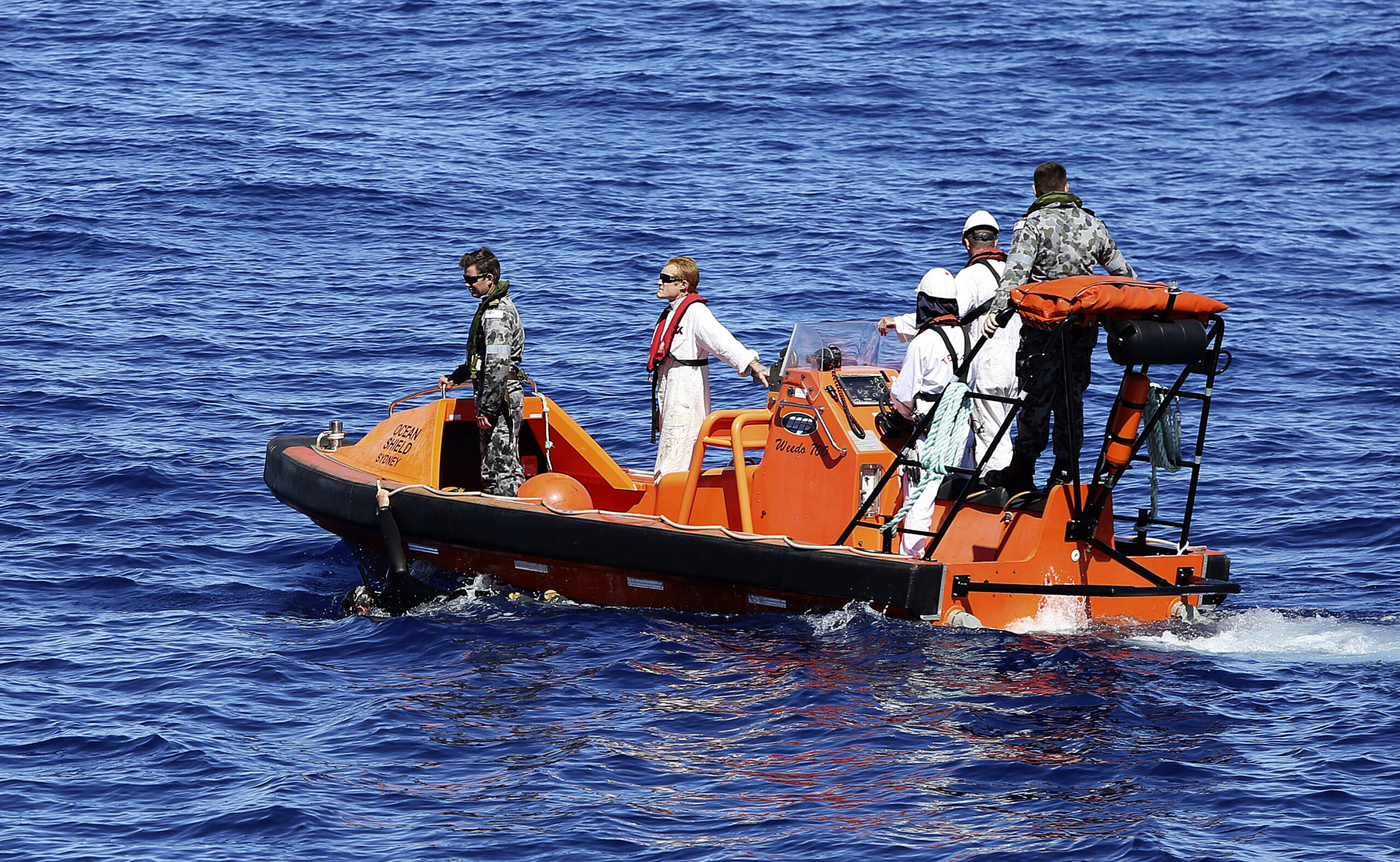 In this April 7, 2014 photo provided by the Australian Defence Force a fast response craft manned by members from the Australian Defence's ship Ocean Shield tows Able Seaman Clearance Diver Michael Arnold as they scan the water for debris of the missing Malaysia Airlines Flight MH370 in the southern Indian Ocean. Up to 14 planes and as many ships were focusing on a single search area covering 77, 580 square kilometers (29,954 square miles) of ocean, 2,270 kilometers (1,400 miles) northwest of the Australian west coast city of Perth, Australia. (AP Photo/ADF, LSIS Bradley Darvill) EDITORIAL USE ONLY (Lsis Bradley Darvill)