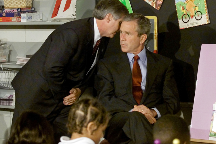 Andrew Card informs George W. Bush of a second plane hitting the World Trade Center, at the Emma E. Booker Elementary School in Sarasota, Florida, September 11, 2001. (Reuters/Win McNamee)