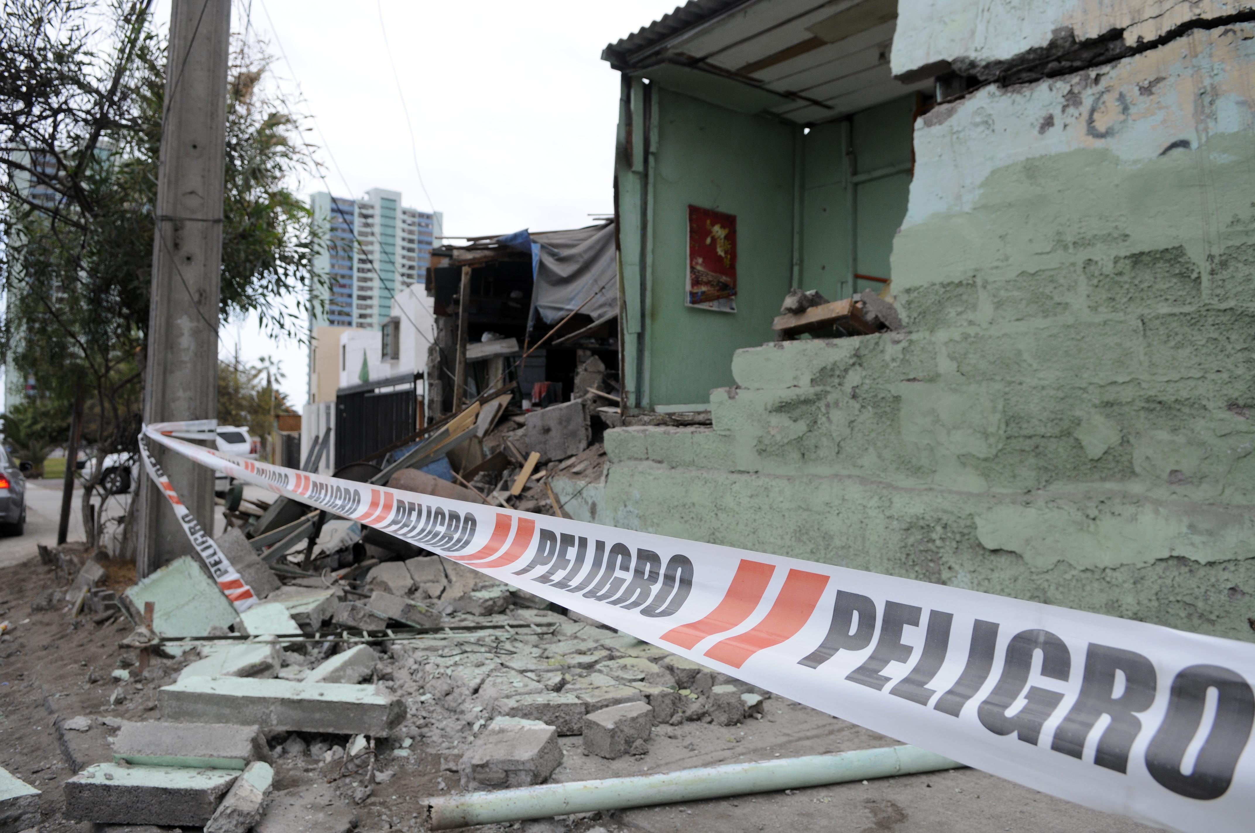 White barricade tape that reads in Spanish; "Danger," blocks off damage caused overnight in the port of Iquique, Chile, Wednesday, April 2, 2014. Chilean authorities discovered surprisingly light damage Wednesday from a magnitude-8.2 quake that struck in the Pacific Ocean, Tuesday evening, near the mining port of Iquique, a northern coastal city of nearly 200,000 people. Six deaths have been reported.  (AP Photo/Cristian Vivero) NO PUBLICAR EN CHILE (AP)