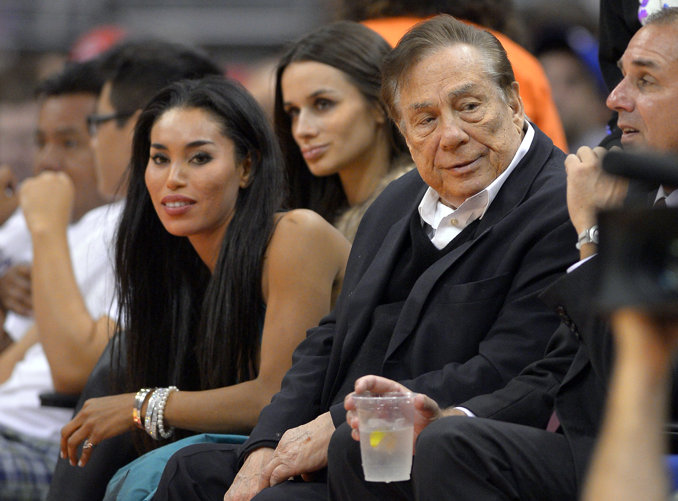 In this photo taken on Friday, Oct. 25, 2013, Los Angeles Clippers owner Donald Sterling, right, and V. Stiviano, left, watch the Clippers play the Sacramento Kings during the first half of an NBA basketball game in Los Angeles. The NBA is investigating a report of an audio recording in which a man purported to be Sterling makes racist remarks while speaking to Stiviano.  NBA spokesman Mike Bass said in a statement Saturday, April 26, 2014, that the league is in the process of authenticating the validity of the recording posted on TMZ's website. Bass called the comments "disturbing and offensive."  (AP Photo/Mark J. Terrill) (AP)