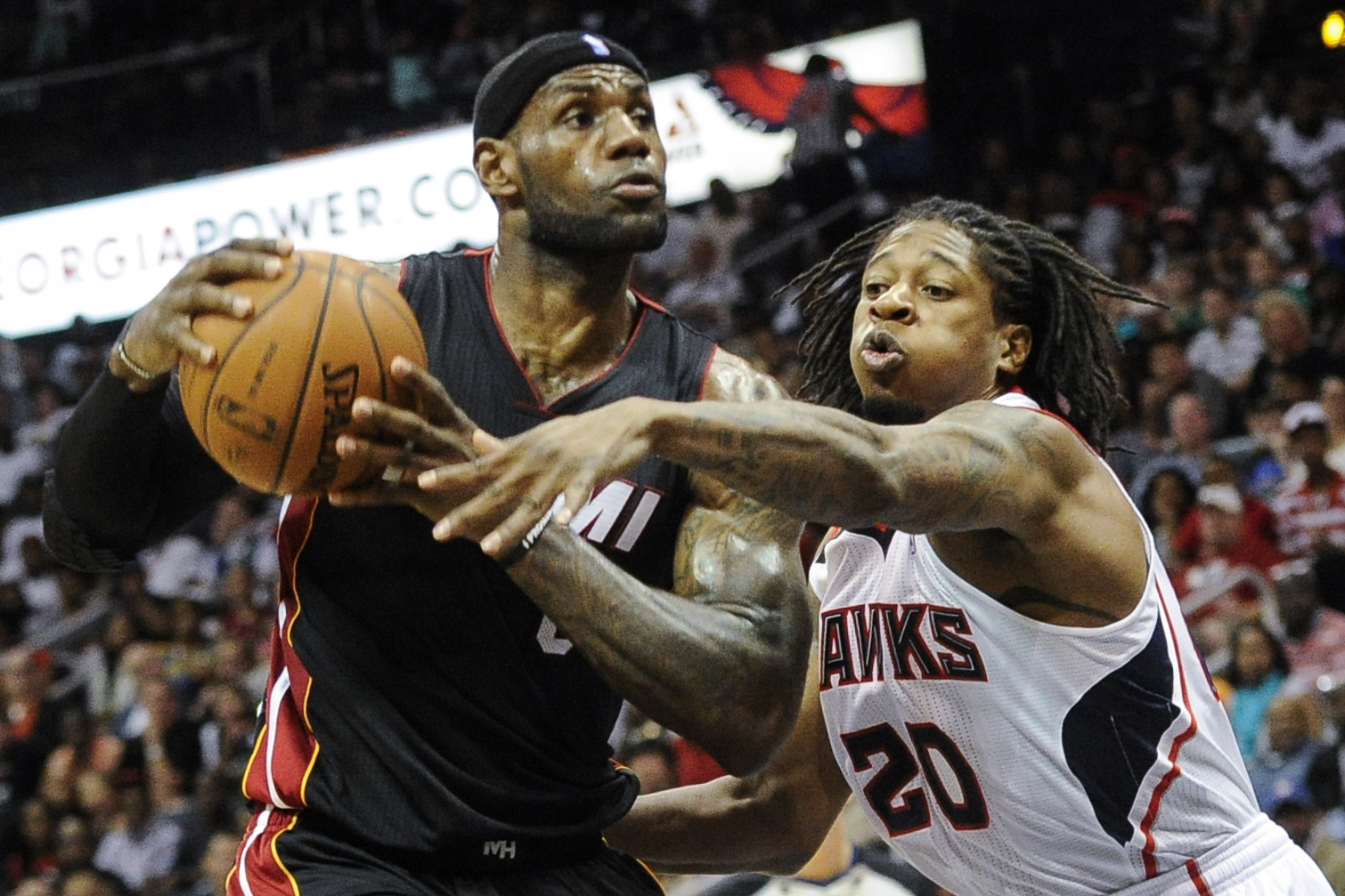 Miami Heat forward LeBron James, left, tries to keep the ball away from the defense of Atlanta Hawks forward Cartier Martin (20) during the second half of an NBA basketball game on Saturday, April 12, 2014, in Atlanta. Atlanta won 98-85. (AP Photo/John Amis) (AP)