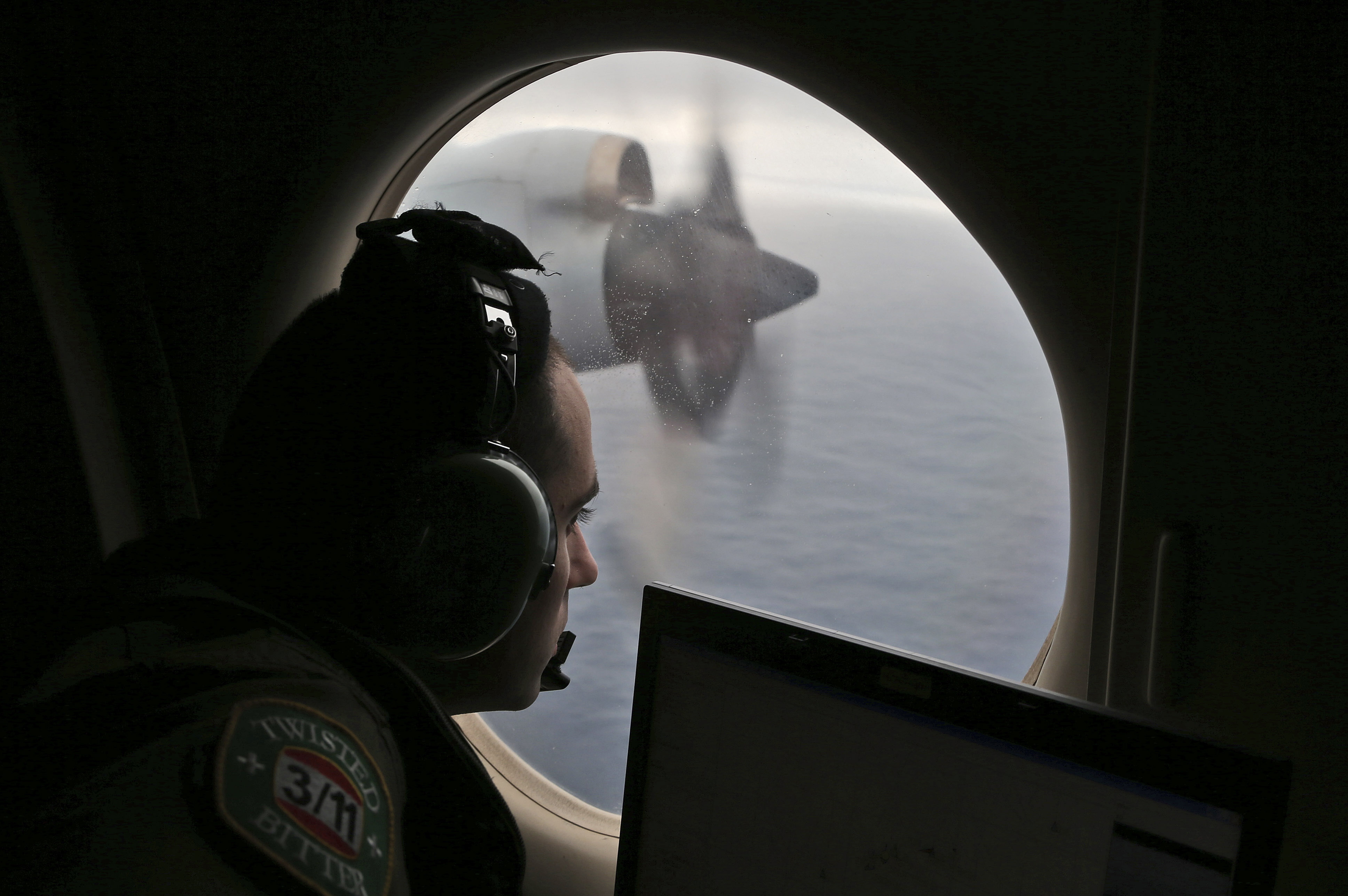 Flight officer Rayan Gharazeddine on board a Royal Australian Air Force AP-3C Orion, searches for the missing Malaysia Airlines Flight MH370 in southern Indian Ocean, Australia, Saturday, March 22, 2014.  A satellite image released by China on Saturday offers the latest sign that wreckage from a Malaysia Airlines plane lost for more than two weeks could be in a remote stretch of the southern Indian Ocean where planes and ships have been searching for three days.  (AP Photo/Rob Griffith, Pool) (Rob Griffith)