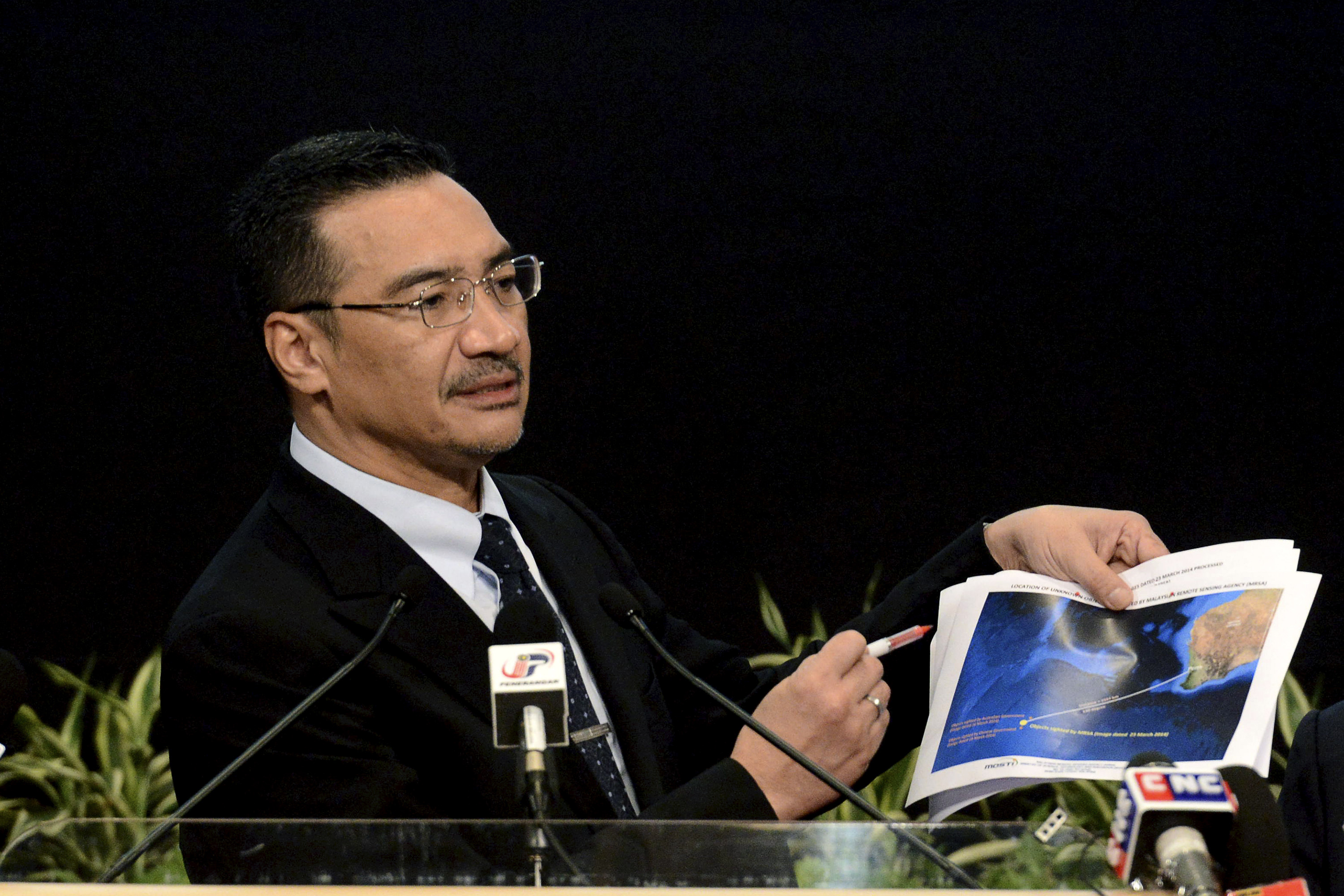 Malaysia's Defense Minister and acting Transport Minister Hishammuddin Hussein shows a printout of the latest satellite image of objects that might be from the missing Malaysia Airlines plane, at Putra World Trade Center in Kuala Lumpur, Malaysia, Wednesday, March 26, 2014. Hishammuddin said the objects were seen close to where three other satellites previously detected objects.  (AP Photo/Joshua Paul) (Joshua Paul)