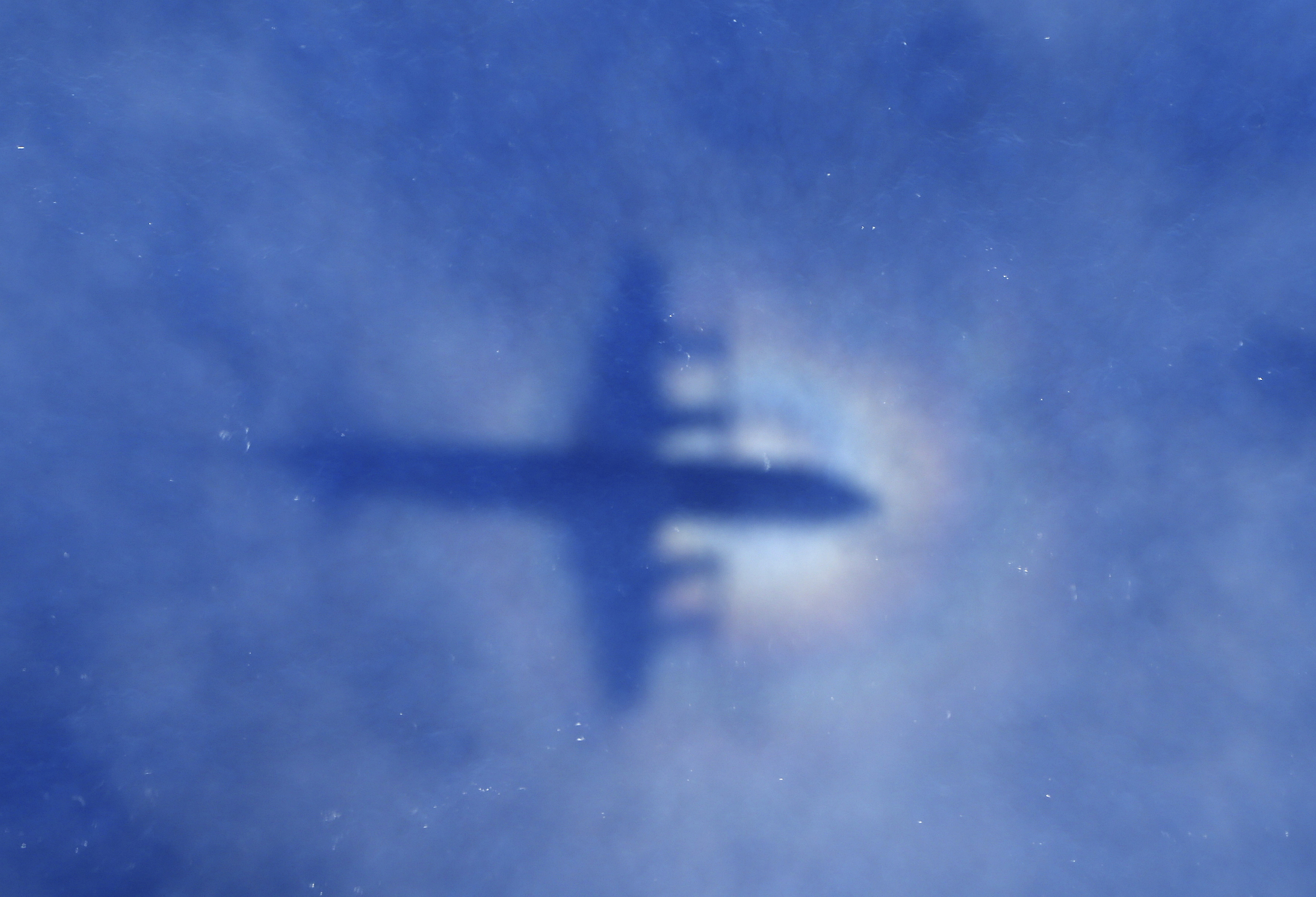 In this March 31, 2014 photo, a shadow of a Royal New Zealand Air Force P-3 Orion aircraft is seen on low cloud cover while it searches for missing Malaysia Airlines Flight MH370 in the southern Indian Ocean. ((AP Photo/Rob Griffith))
