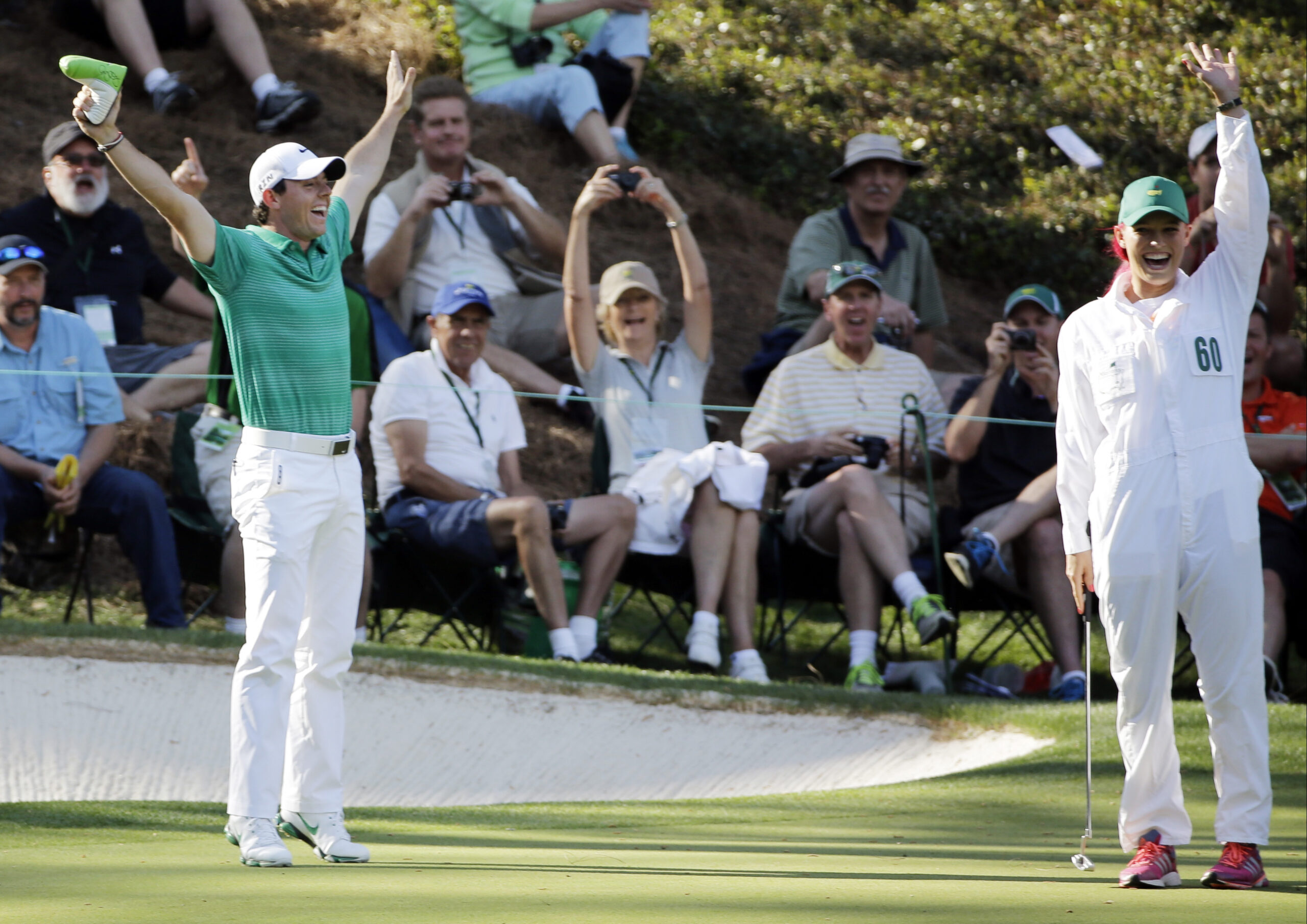 Tennis player Caroline Wozniacki and her fiancee Rory McIlroy, of Northern Ireland, celebrate after Wozniacki putted on the ninth hole during the par three competition at the Masters golf tournament Wednesday, April 9, 2014, in Augusta, Ga. (AP Photo/David J. Phillip) (David J. Phillip)