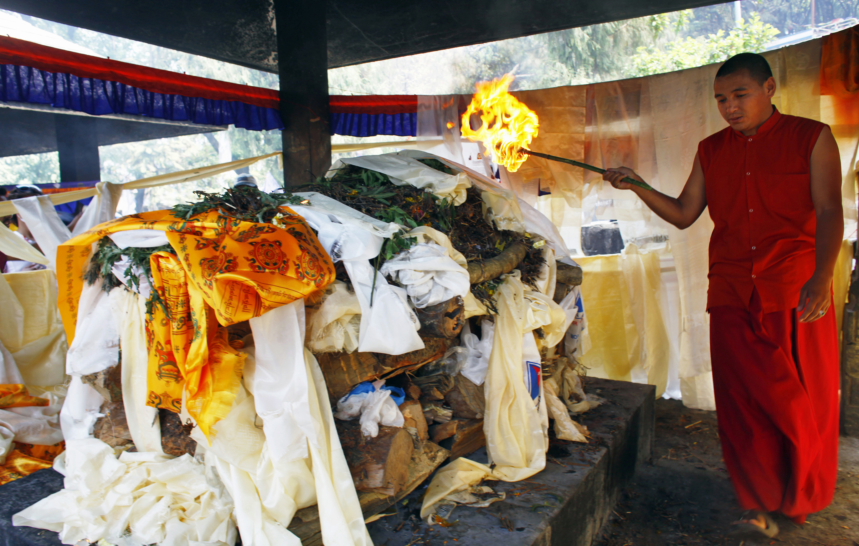 A Buddhist monk lights the funeral pyre of Nepalese mountaineer Ang Kaji Sherpa, killed in an avalanche on Mount Everest, during his funeral ceremony in Katmandu, Nepal, Monday, April 21, 2014. Buddhist monks cremated the remains of Sherpa guides who were buried in the deadliest avalanche ever recorded on Mount Everest, a disaster that has prompted calls for a climbing boycott by Nepal's ethnic Sherpa community. The avalanche killed at least 13 Sherpas. Three other Sherpas remain missing and are presumed dead. (AP Photo/Niranjan Shrestha) (AP)