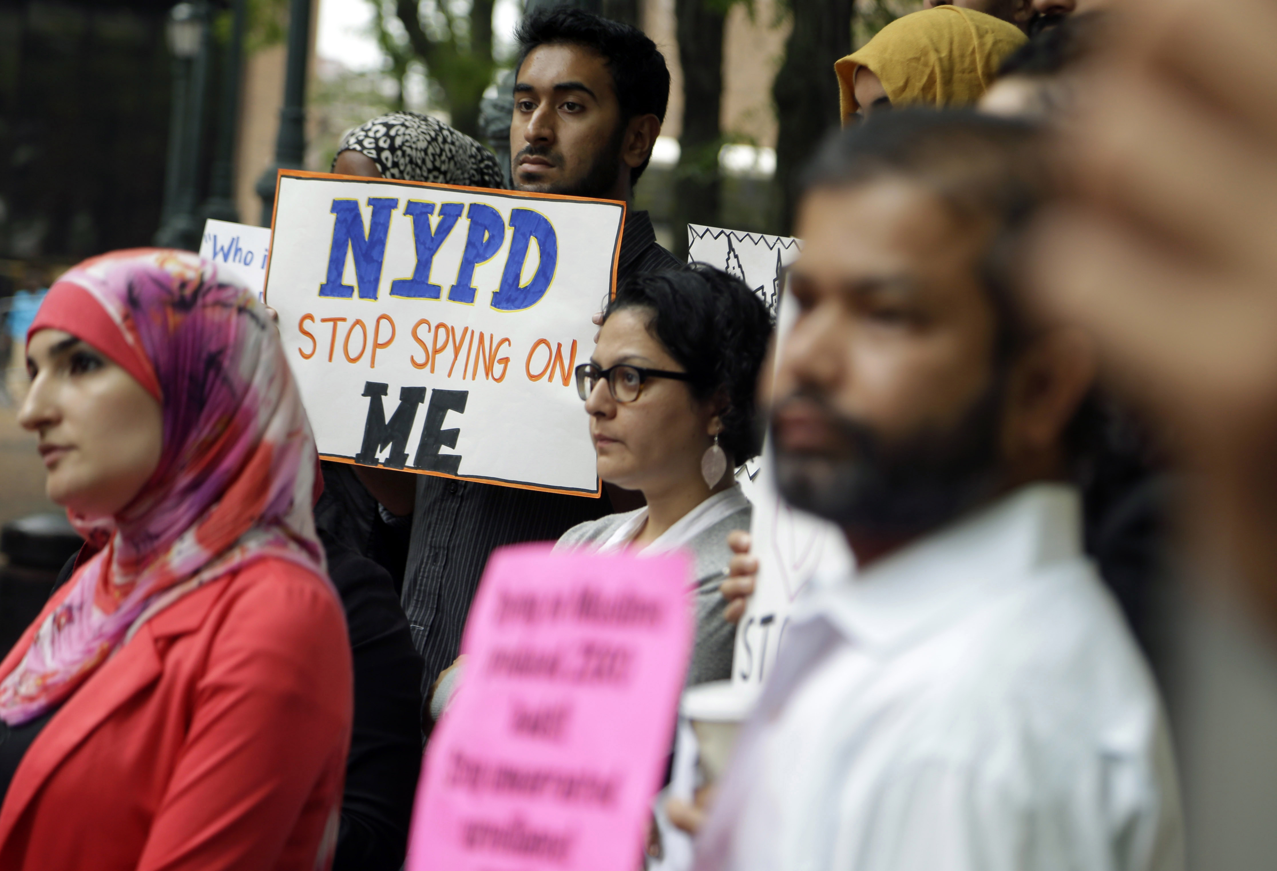 FILE - In this Aug. 28, 2014, file photo, a group of people hold signs protesting the New York Police Departments program of infiltrating and informing on Muslim communities during a rally near police headquarters in New York. On Tuesday, April 15, 2014, the NYPD confirmed it disbanded the special intelligence unit that monitored Muslim communities in New York and New Jersey. (AP Photo/Seth Wenig, File) (AP)