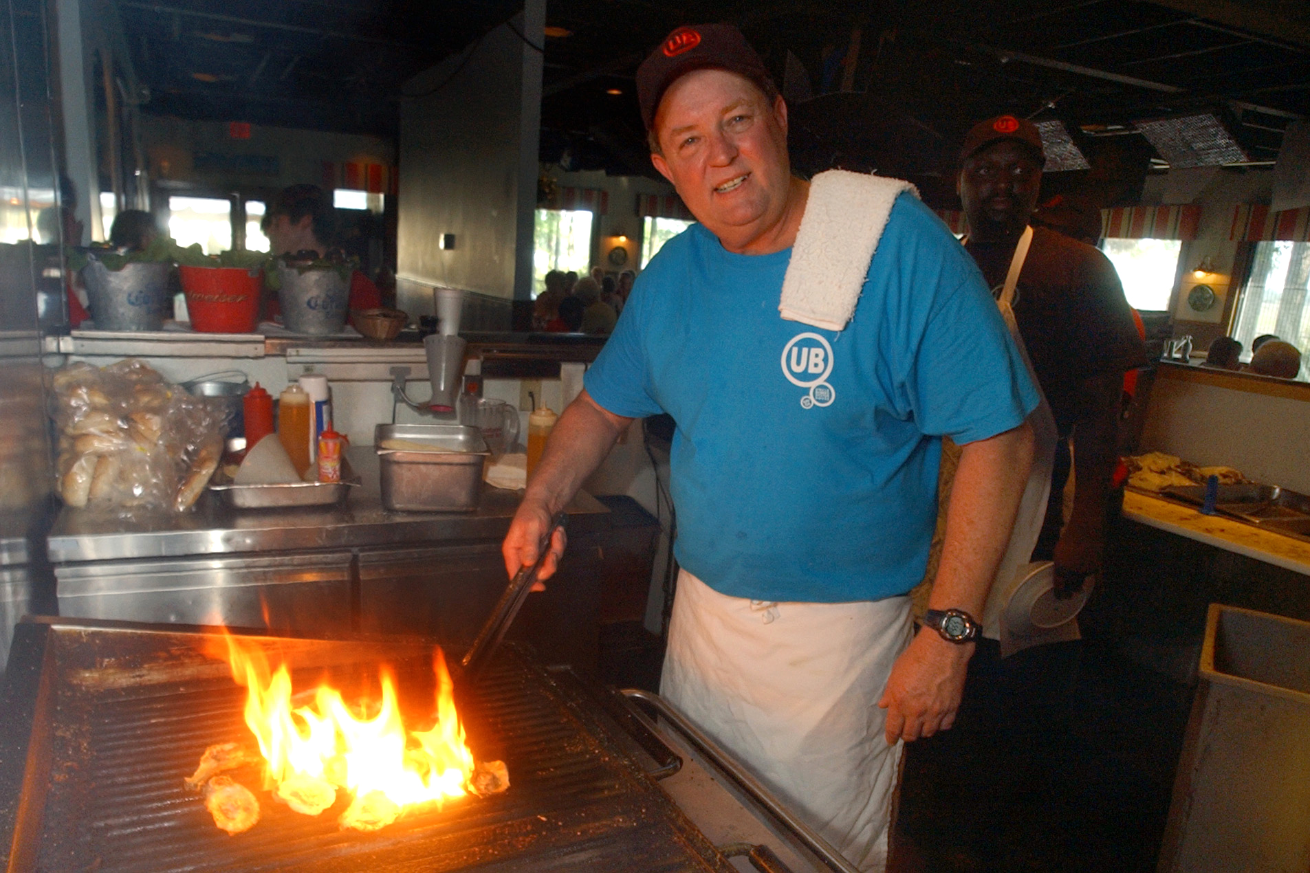 FILE - In this June 23, 2006 file photo, Uncle Bubba's Oyster House chef and owner Bubba Hiers, who is also Paula Deen's brother, grills oysters at the Savannah, Ga. restaurant. The wildly popular Georgia restaurant at the center of a lawsuit that left the reputation of famed Southern celebrity cook Paula Deen in shambles has reportedly closed. The Savannah Morning News and WSAV television both reported Thursday April 3, 2014 that Uncle Bubba's Seafood & Oyster House announced the closure on its Facebook page.  (AP Photo/Stephen Morton, File) (AP)