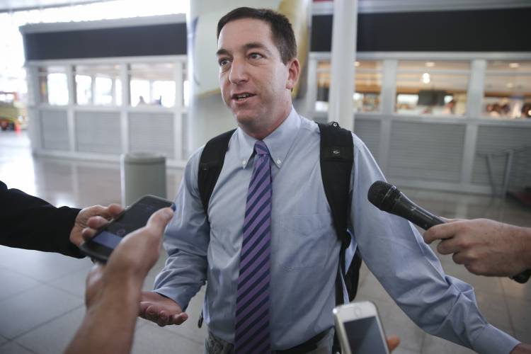 Glenn Greenwald speaks to the media after arriving at John F. Kennedy International Airport, on Friday (AP)