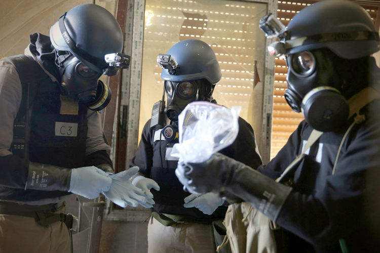 A U.N. chemical weapons expert holds a plastic bag containing samples from one of the sites of an alleged chemical weapons attack in Damascus, August 29, 2013. (Reuters/Mohamed Abdullah)