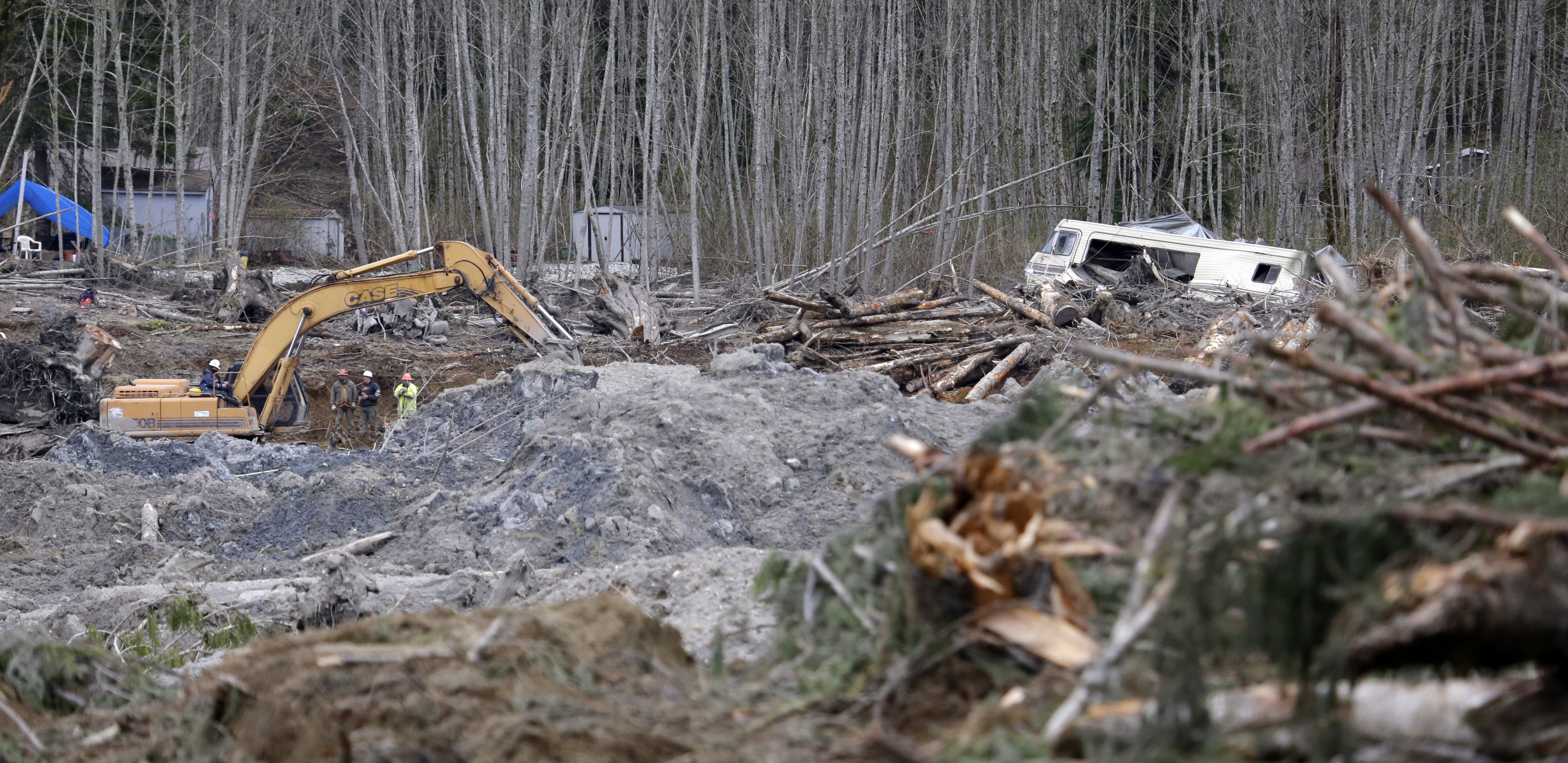 A demolished recreational vehicle lies in a debris field at the scene of a deadly mudslide nearly two weeks earlier nearby, Thursday, April 3, 2014, in Oso, Wash. (AP Photo/Elaine Thompson)