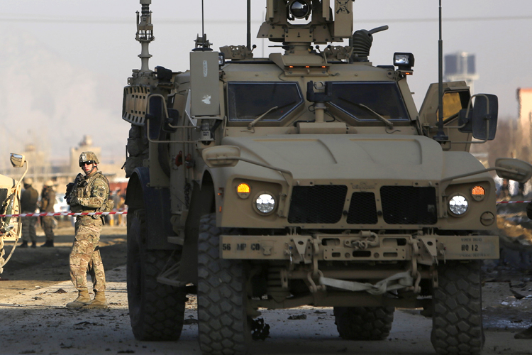 A U.S. soldier stands at the site of a suicide car bomb attack in Kabul February 10, 2014. A car bomb in the Afghan capital Kabul killed two United States contractors for the international security force ISAF on Monday, the NATO-led force and a U.S. official said. (Reuters/Mohammad Ismail)