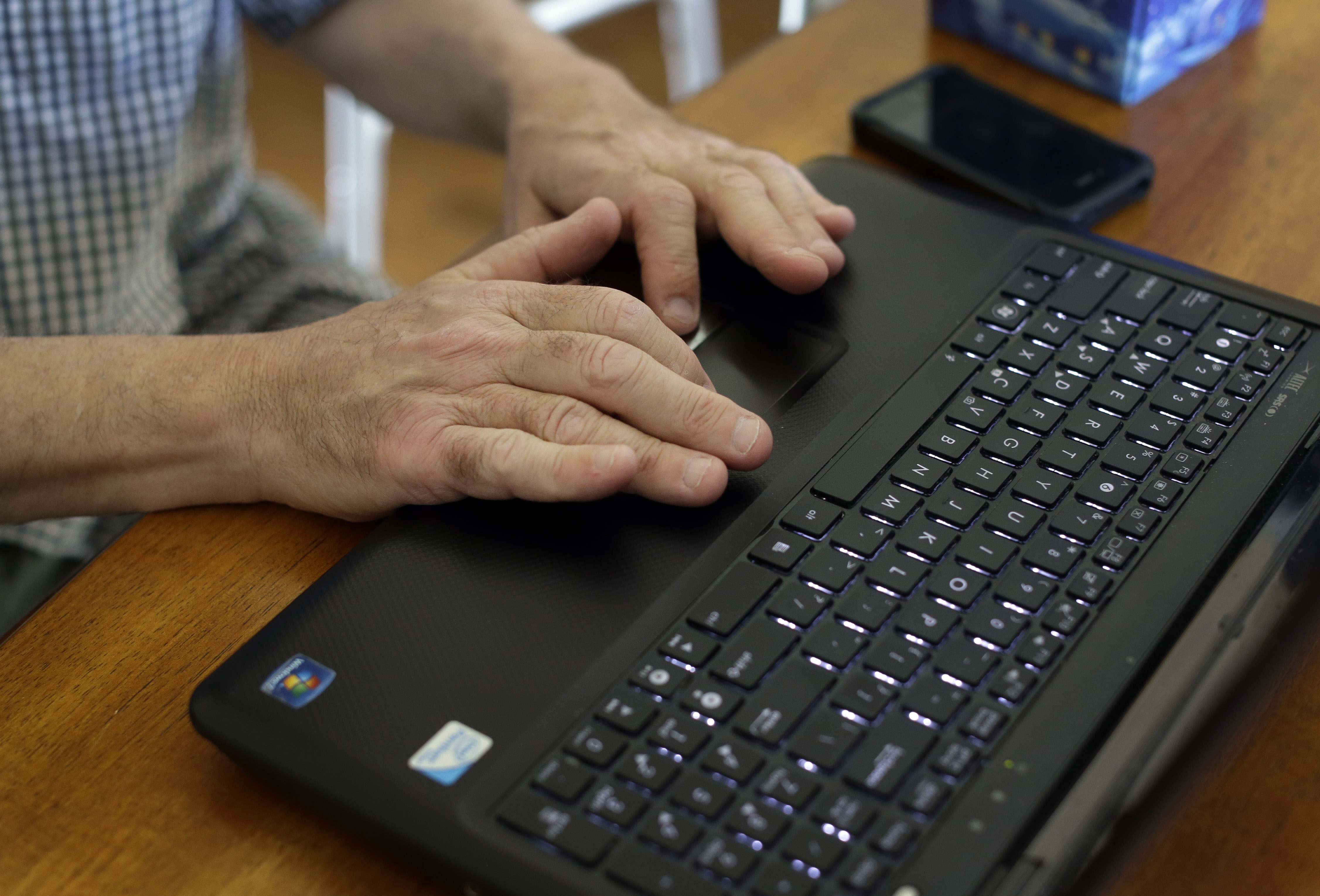 This photo taken May 8, 2014 shows Mark Matulaitis working on his laptop that he uses for virtual house calls with his neurologist in his home in Salisbury, Md. Matulaitis has had Parkinson's disease since 2011 and sees a neurologist at the University of Rochester via his laptop and special Skype-like software.  (AP Photo/Patrick Semansky) (AP)