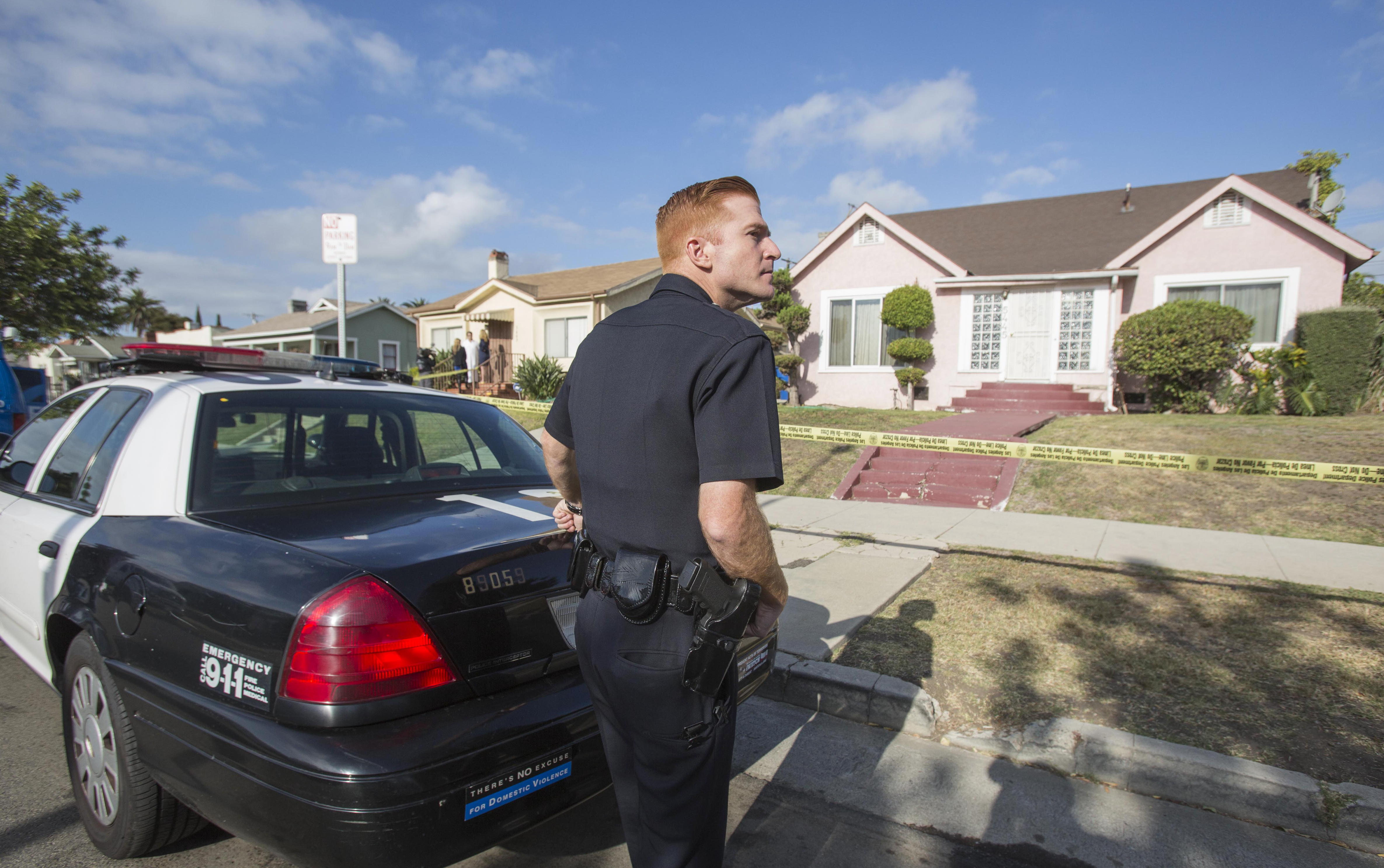 A police officer stands guard in front of the home of actor Michael Jace on Tuesday, May 20, 2014, in Los Angeles.  Jace, who played a police officer on the hit TV show "The Shield," was arrested on suspicion of homicide after his wife was found shot to death in their Los Angeles home, authorities said. Police arrived at the couple's home around 8:30 p.m. Monday after a report of shots fired, Officer Chris No said. April Jace, 40, was found dead inside, officials said.  Jace was taken into custody and booked early Tuesday on suspicion of homicide, No said. He was being held in a Los Angeles jail in lieu of $1 million bail.   (AP Photo/Ringo H.W. Chiu) (AP)