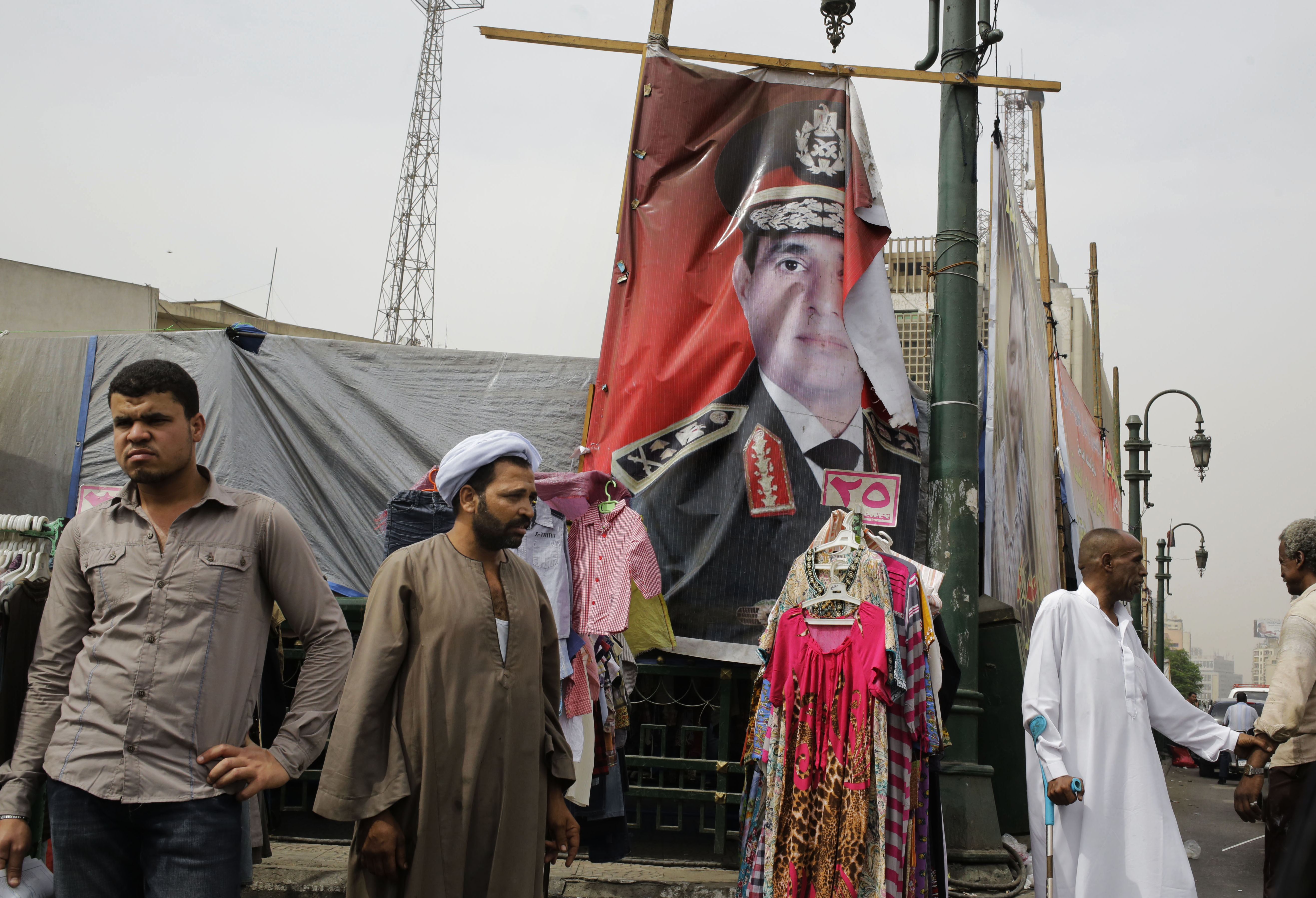 Egyptians wait for transportation near a banner with the portrait of Egyptian presidential candidate Abdel-Fattah el-Sissi in Cairo, Egypt, Wednesday, May 28, 2014. (AP Photo/Amr Nabil) (AP)
