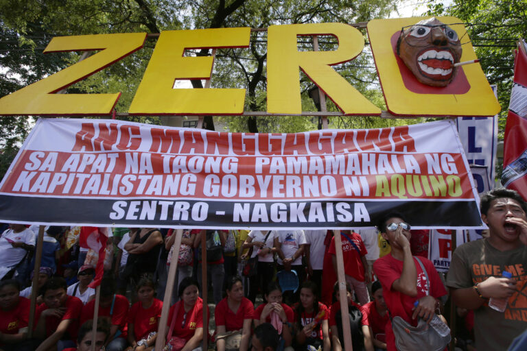 Workers shout slogans as they hold a rally near the Presidential Palace to mark the Labor Day celebrations on Thursday, May 1, 2014 in Manila, Philippines. Various labor groups nationwide held protests, mostly to demand wage hikes, better working conditions and an end to corruption in the government. The sign reads: Workers Have Zero Benefits In The Four Years of Capitalist Government of Aquino. (AP Photo/Bullit Marquez) (Bullit Marquez)