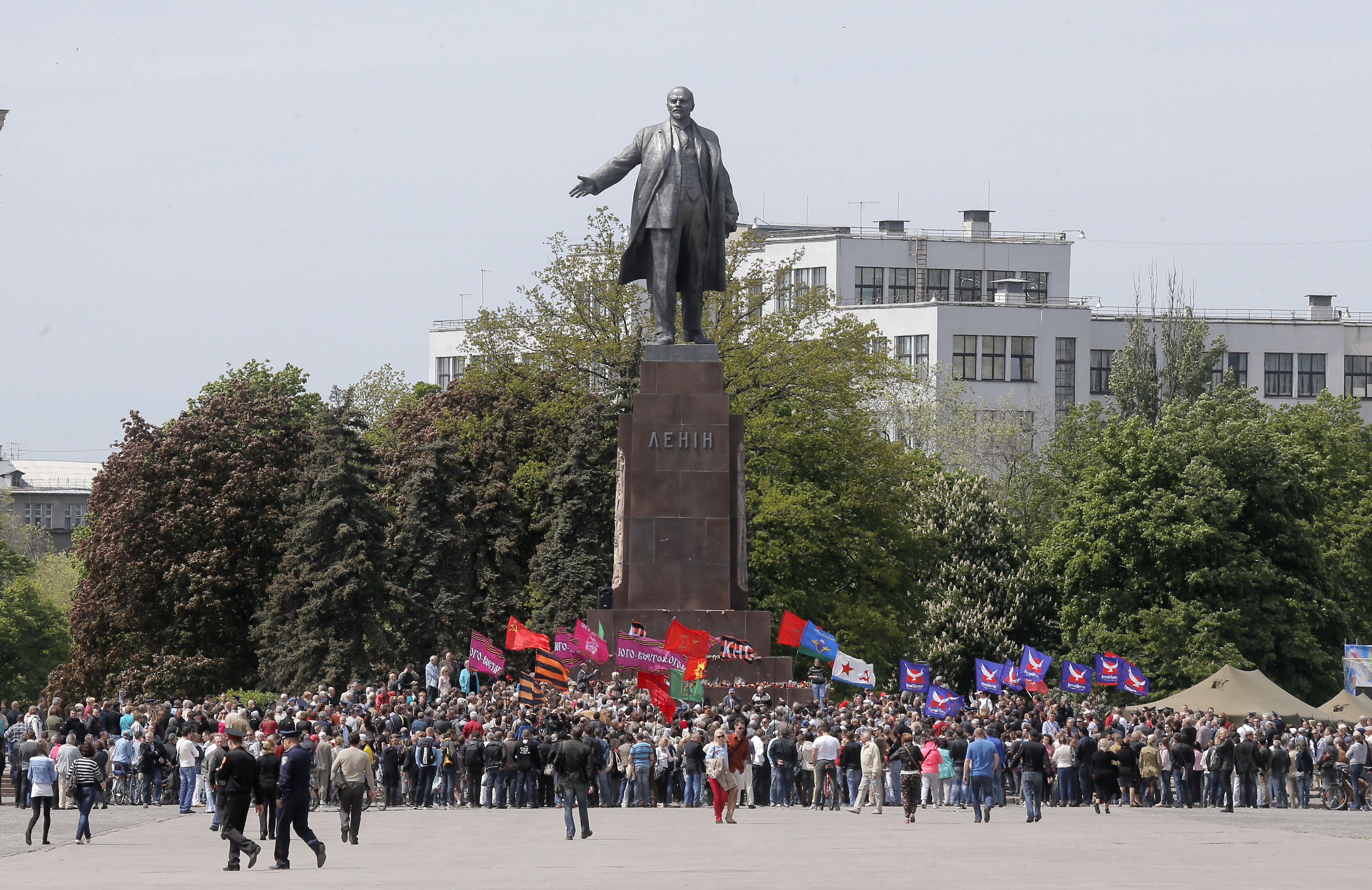 Ukrainians take part in a rally in front of a monument of Soviet revolutionary leader Vladimir Lenin, during a Victory Day celebration, which commemorates the 1945 defeat of Nazi Germany, in Kharkiv, Ukraine, Friday, May 9, 2014. Putin's surprise call on Wednesday for delaying the referendum in eastern Ukraine appeared to reflect Russia's desire to distance itself from the separatists as it bargains with the West over a settlement to the Ukrainian crisis. But insurgents in the Russian-speaking east defied Putin's call and said they would go ahead with the referendum. (AP Photo/Efrem Lukatsky) (AP)