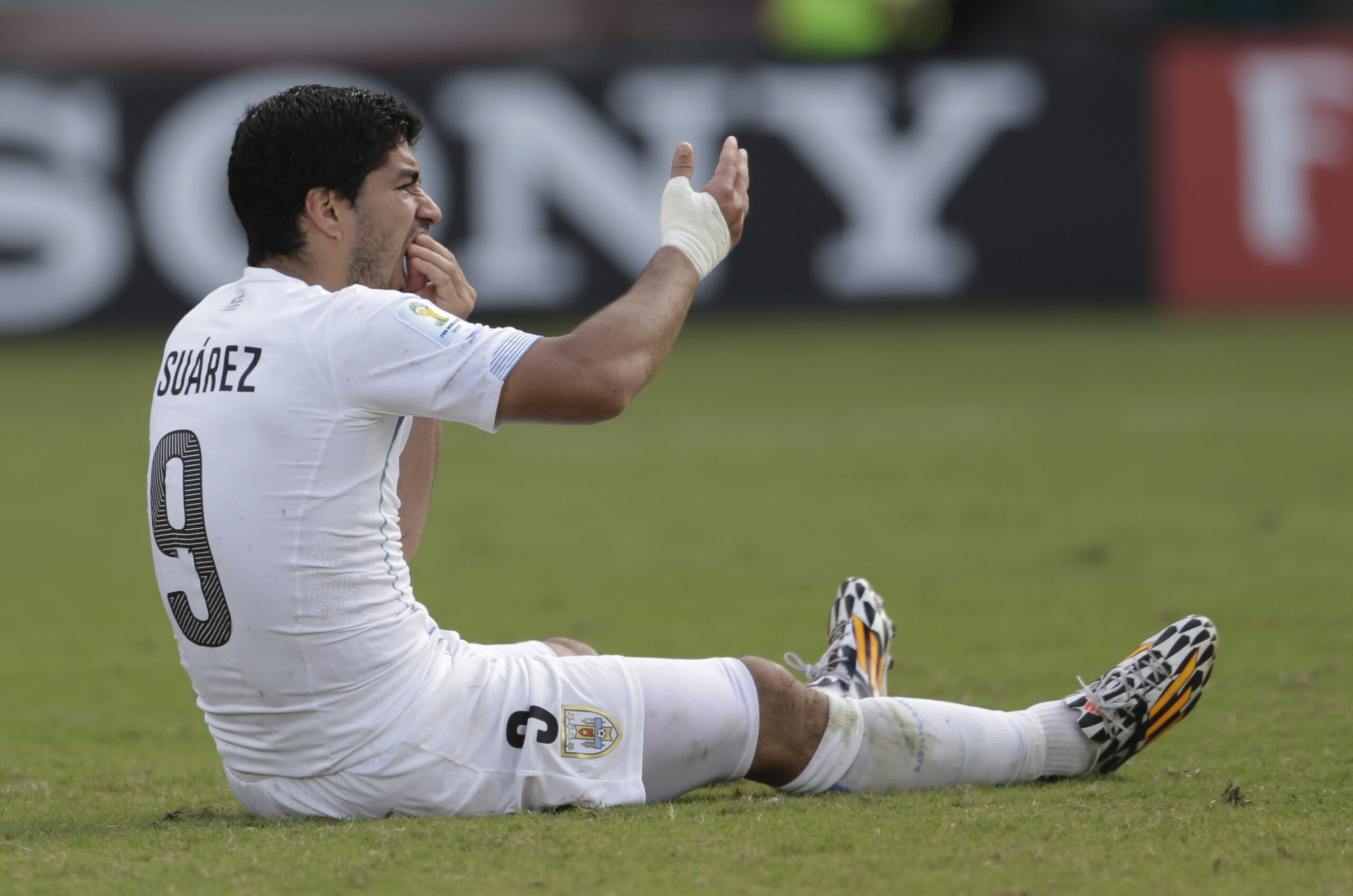 Uruguay's Luis Suarez holds his teeth after running into Italy's Giorgio Chiellini's shoulder during the group D World Cup soccer match between Italy and Uruguay at the Arena das Dunas in Natal, Brazil, Tuesday, June 24, 2014. (AP/Petr David Josek)