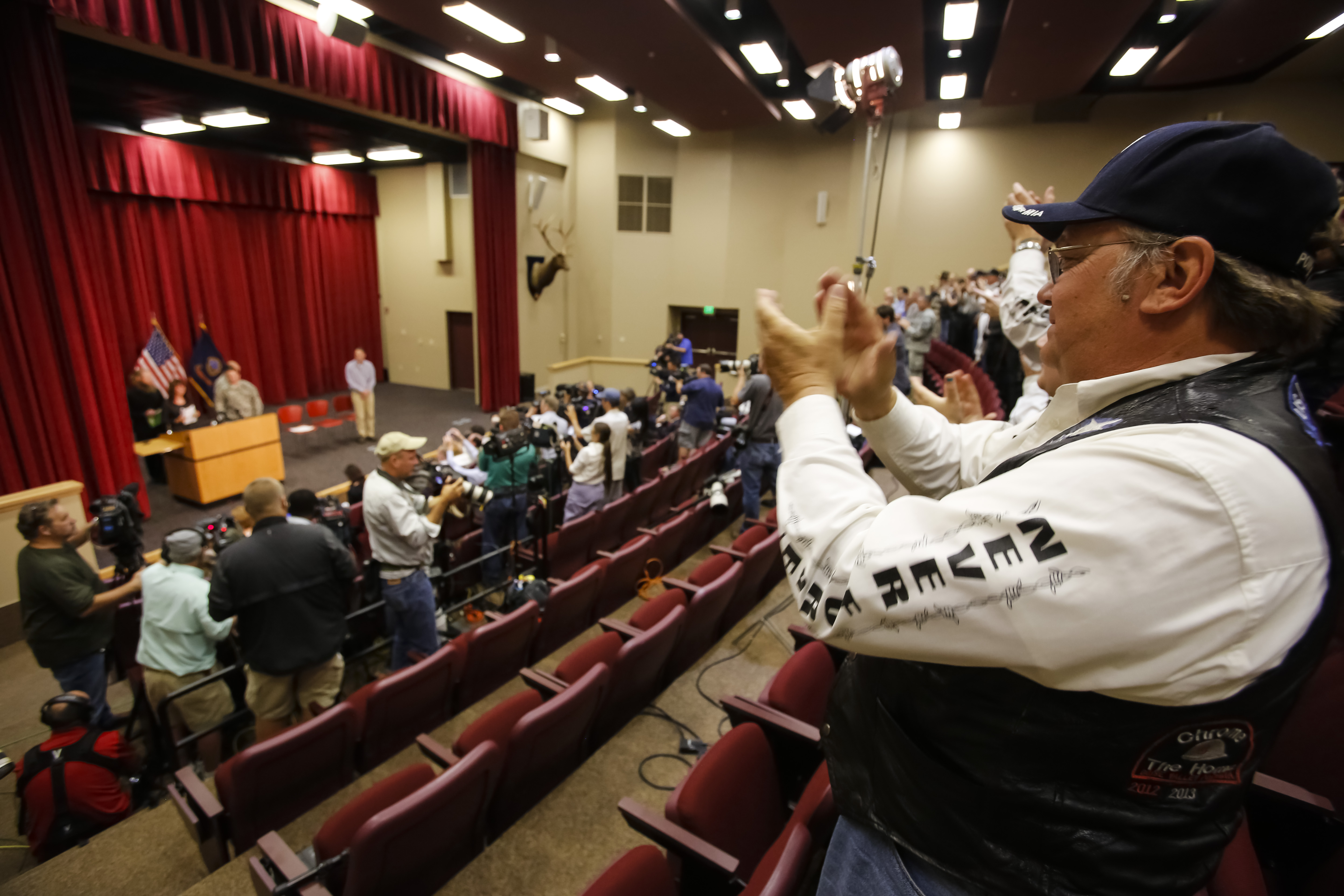 Jani and Bob Bergdahl come to the podium in front of the media as the Boise Valley POW-MIA biker group, including  acting director Ralph Kramer, right, stand and applaud at the start of a press conference at Gowen Field in Boise, Idaho, on Sunday, June 1, 2014. (AP Photo/Otto Kitsinger) (AP)