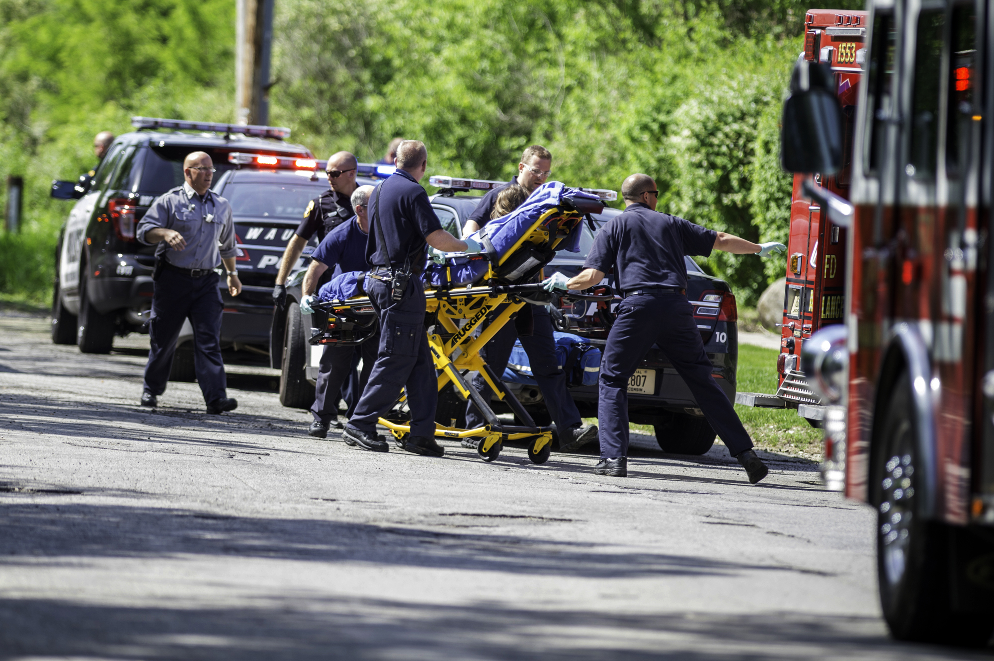 In this Saturday, May 31, 2014 photo, rescue workers take a stabbing victim to the ambulance in Waukesha, Wis. (AP/Abe Van Dyke)
