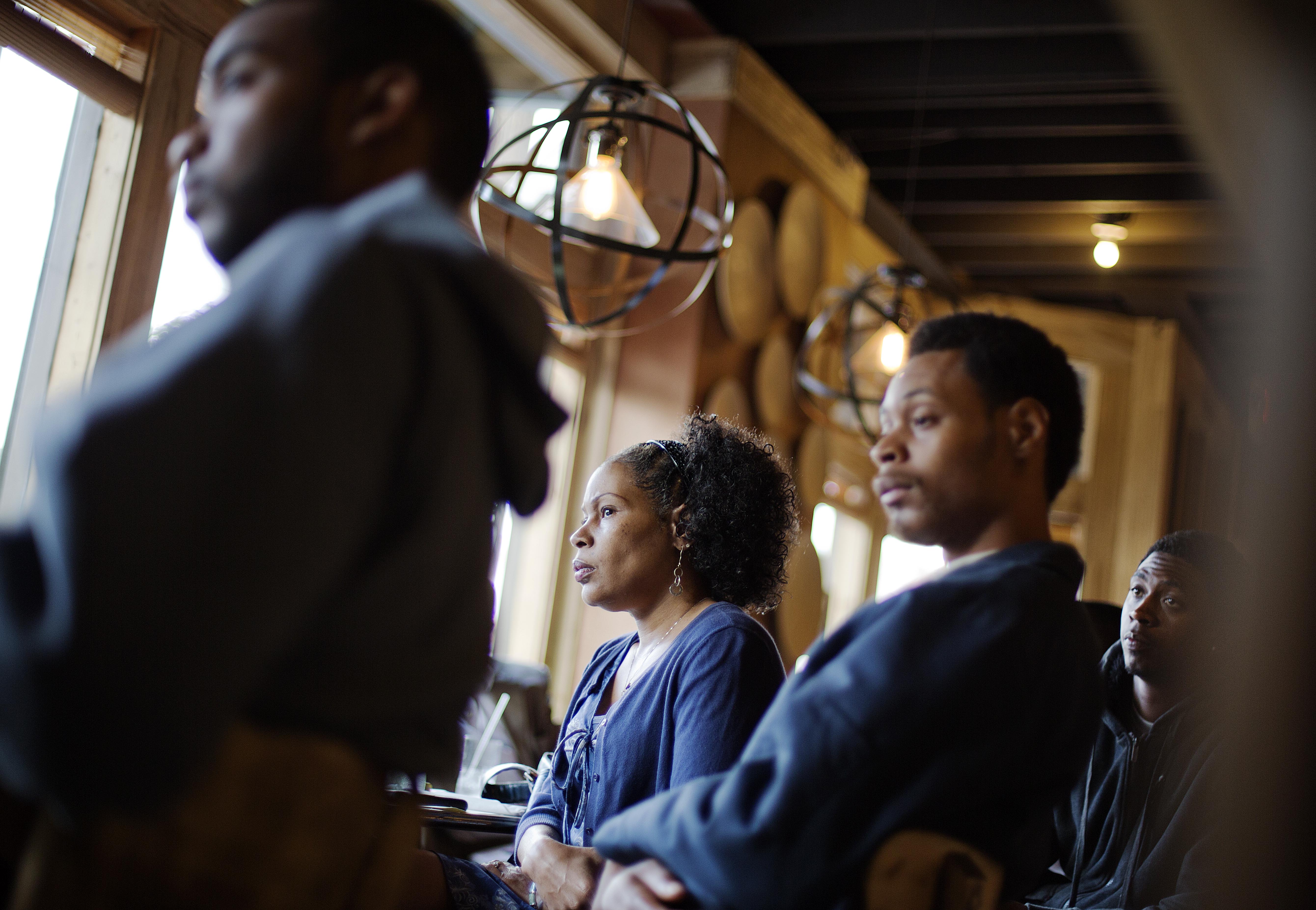 In this photo taken May 18, 2014, Lisa Marie Hyman-Walker, center, and son Eugene Mosby, right, listen to Leo Smith (not shown), minority engagement director for the Georgia Republican Party, speaking at the Delightful Eatz Bar and Grill in the historically African American neighborhood of Edgewood in Atlanta. Smith is on the GOP's front lines recruiting African-American voters in pivotal states. (AP Photo/David Goldman) (AP)