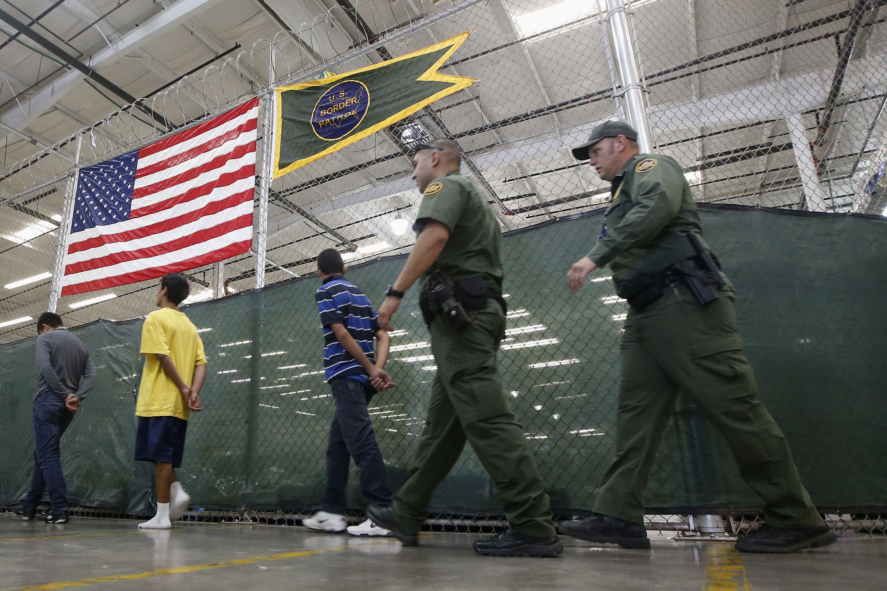 Detainees are escorted to an area to make phone calls as hundreds of mostly Central American immigrant children are being processed and held at the U.S. Customs and Border Protection Nogales Placement Center on Wednesday, June 18, 2014, in Nogales, Ariz.  CPB provided media tours Wednesday of two locations in Brownsville, Texas, and Nogales, that have been central to processing the more than 47,000 unaccompanied children who have entered the country illegally since Oct. 1. (AP Photo/Ross D. Franklin, Pool) (AP)