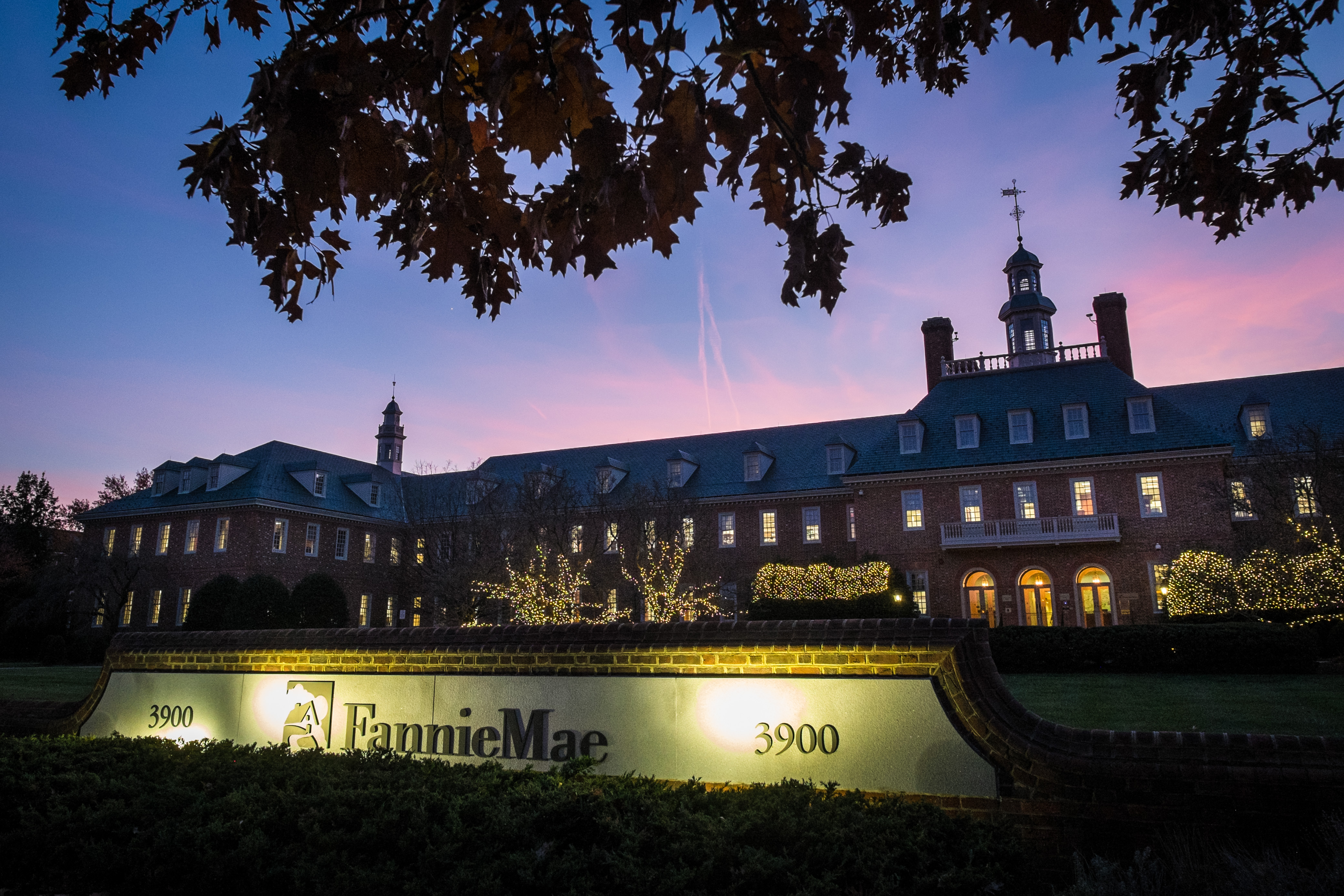In this Nov. 20, 2013, photo, the sun sets behind the Fannie Mae headquarters in Washington. Alleged insurance kickbacks collected by banks and other mortgage servicers may have cost government-controlled mortgage giants Fannie Mae and Freddie Mac an estimated $168 million, according to an inspector generals report. (AP Photo/J. David Ake) (AP)