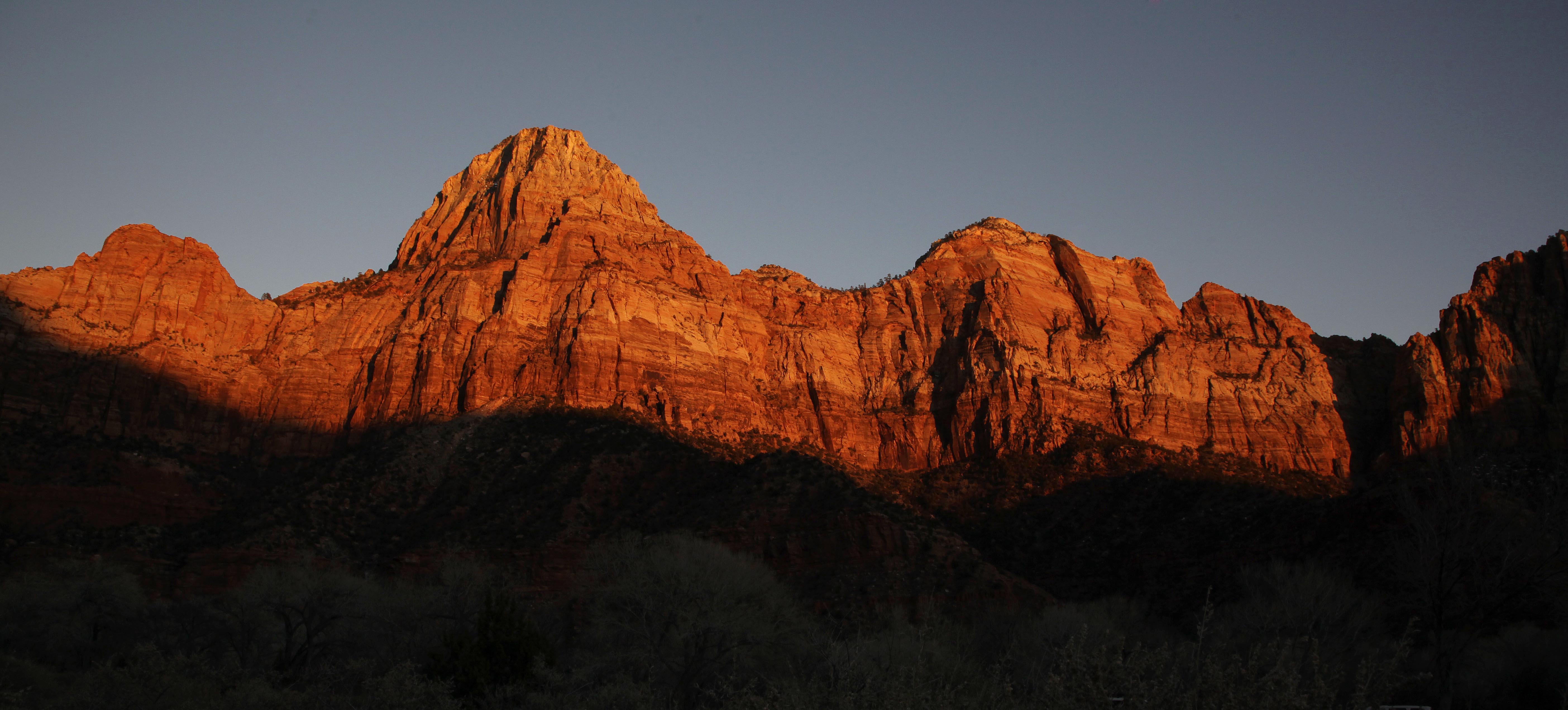 FILE - This Jan. 20, 2011 file photo shows shadows creeping up on sandstone cliffs glowing red as the sun sets on Zion National Park near Springdale, Utah. The National Park Service is taking steps to ban drones from 84 million acres of public lands and waterways, saying the unmanned aircraft annoy visitors, harass wildlife and threaten safety. Jonathan Jarvis, the park services director, told The Associated Press he was signing a policy memorandum on Friday directing superintendents of the services 401 parks to write rules prohibiting the launching, landing or operation of unmanned aircraft in their parks.  (AP Photo/Julie Jacobson, file) (AP Photo/Julie Jacobson, file)