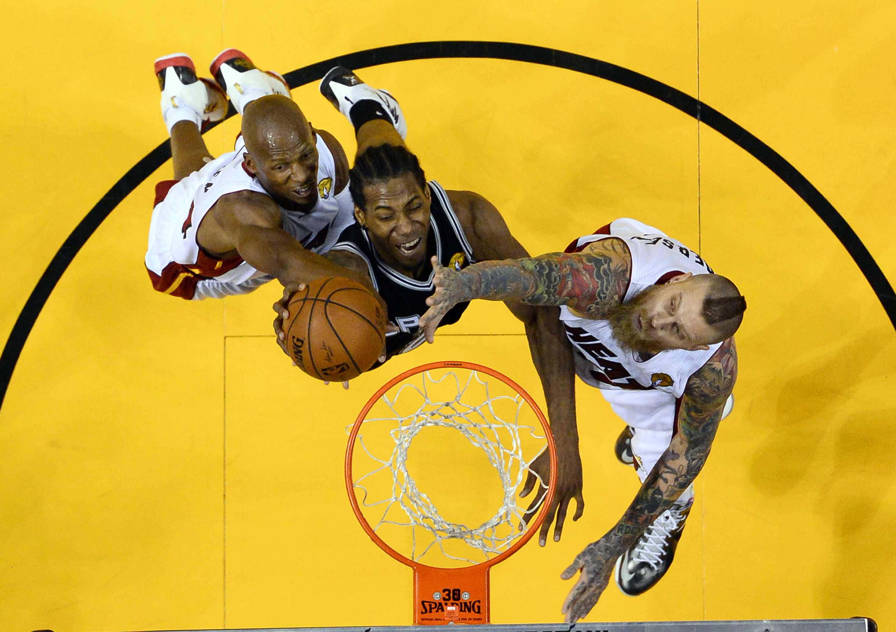 Miami Heat guard Ray Allen, left, and forward Chris Andersen block a shot by San Antonio Spurs forward Kawhi Leonard, center, in the second half in Game 3 of the NBA basketball finals in Miami, Tuesday, June 10, 2014. The Spurs won 111-92. (AP Photo/Larry W. Smith, Pool) (AP)