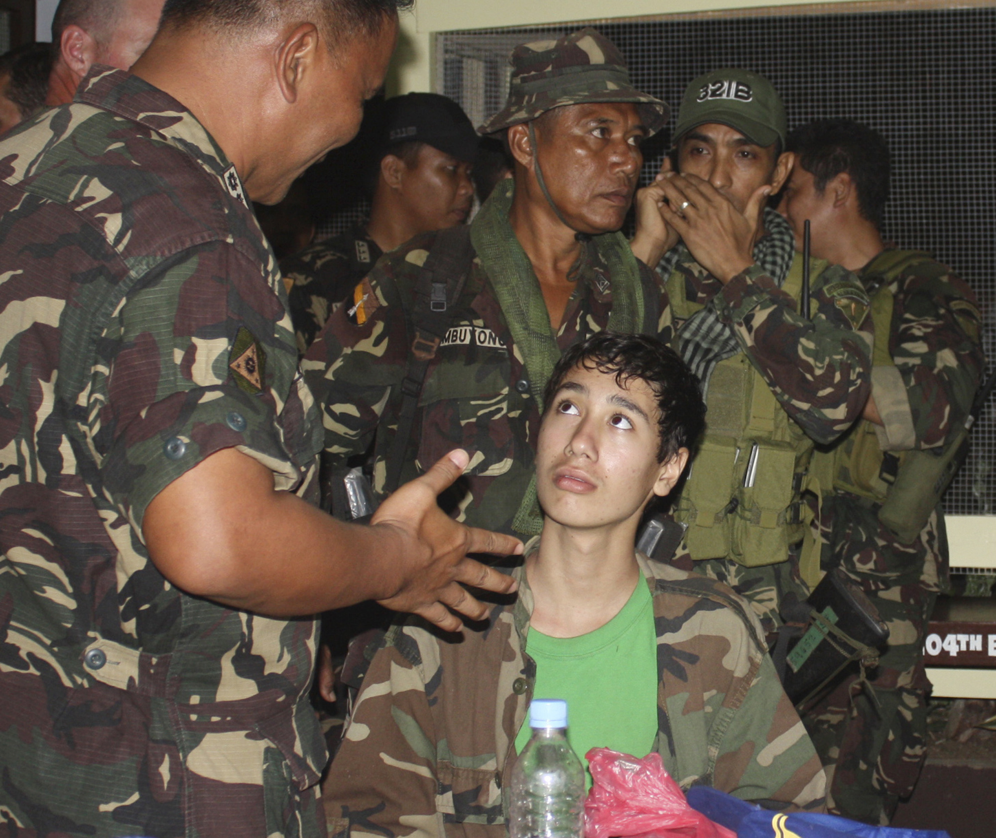In this photo taken Saturday Dec. 10, 2011, Kevin Lunsman, a kidnapped American teenage boy, talks to Filipino soldiers inside the Philippine military compound in Zamboanga city, southern Philippines following his escape from suspected al-Qaida-linked militants. Lunsman, 14, wandered without shoes for two days in a southern Philippine jungle before villagers found him, ending his five-month captivity, officials said Sunday. Lunsmann, claimed to have told his four armed captors that he would take a bath in a stream and then made a dash for freedom Friday in Basilan province, police Senior Supt. Edwin de Ocampo said. He followed a river down a mountain until villagers found him late the next day, de Ocampo said. (AP Photo) (Anonymous)